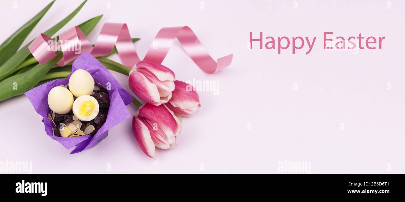 Œufs de Pâques. Bonne carte de pâques. Œufs de Pâques et tulipes avec ruban sur fond en bois blanc. Fond de Pâques. Œufs de Pâques. Carte de Pâques. Pâques g Banque D'Images