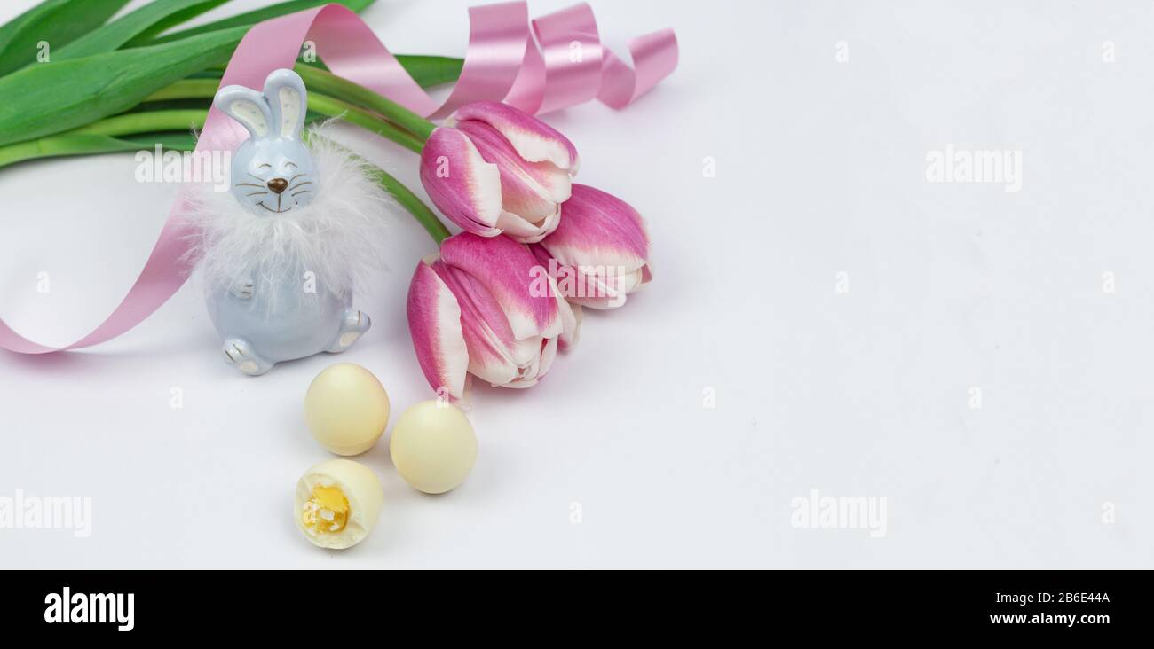 Œufs de Pâques. Bonne carte de pâques. Œufs de Pâques avec tulipes roses sur fond blanc. Bannière. Tulipes lapin. Endroit pour le texte Banque D'Images