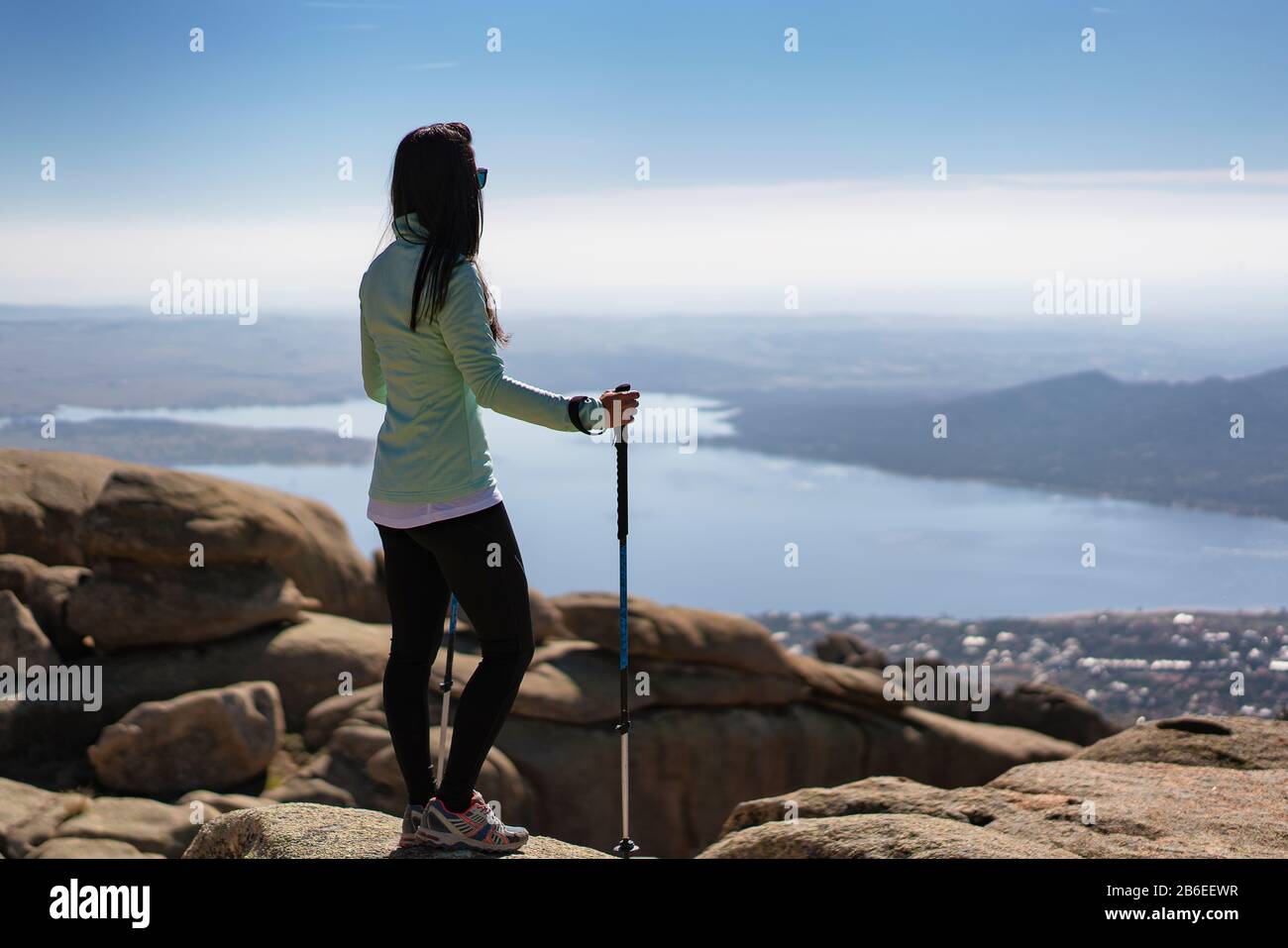 Vue panoramique d'une jeune femme qui se promenait à la Pedriza avec le réservoir Santillana, Manzanares El Real, Madrid, Espagne. Banque D'Images