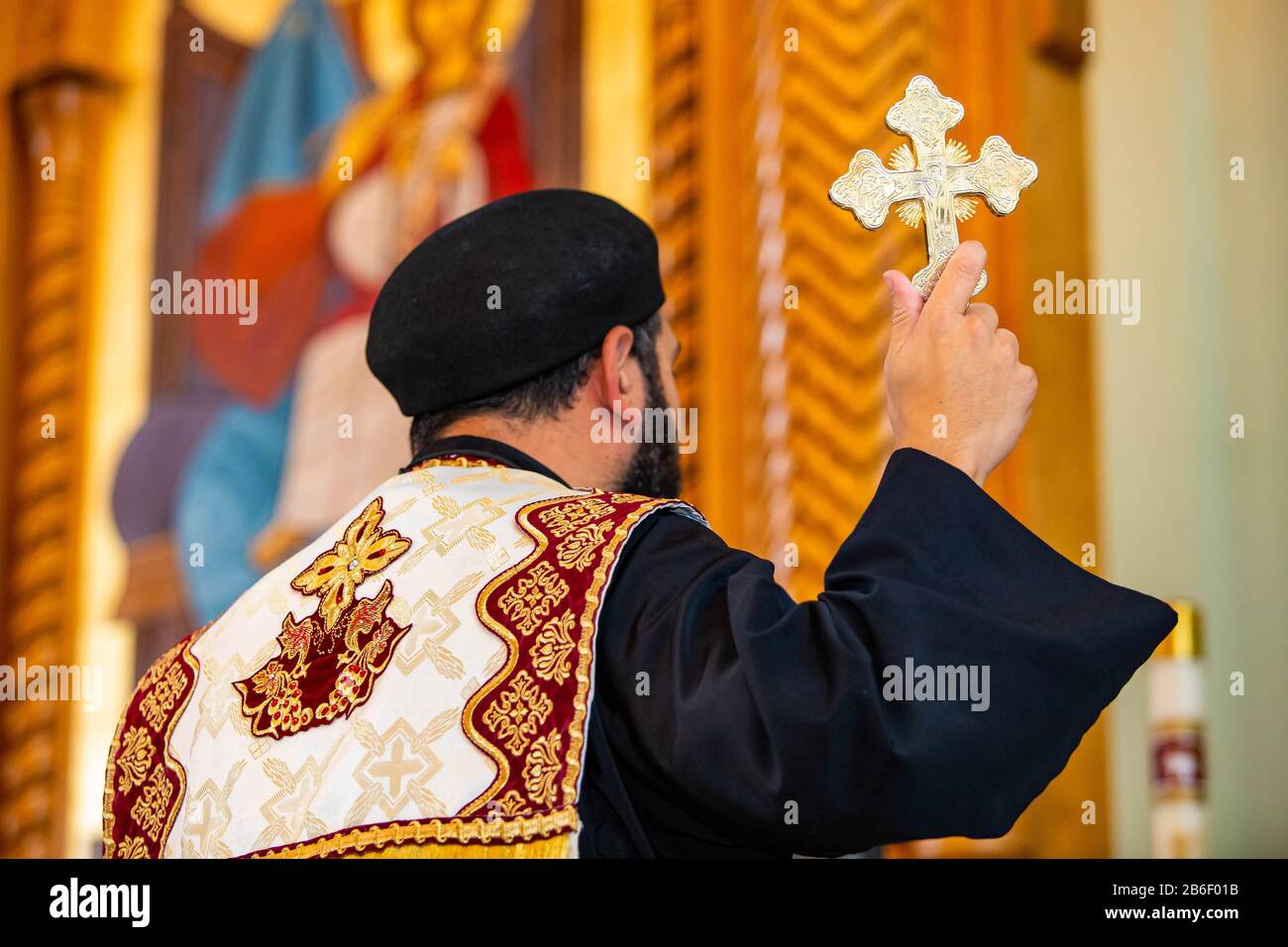 Prêtre du Saint-père tenant un symbole de croix dorée pendant la cérémonie sacrée Banque D'Images