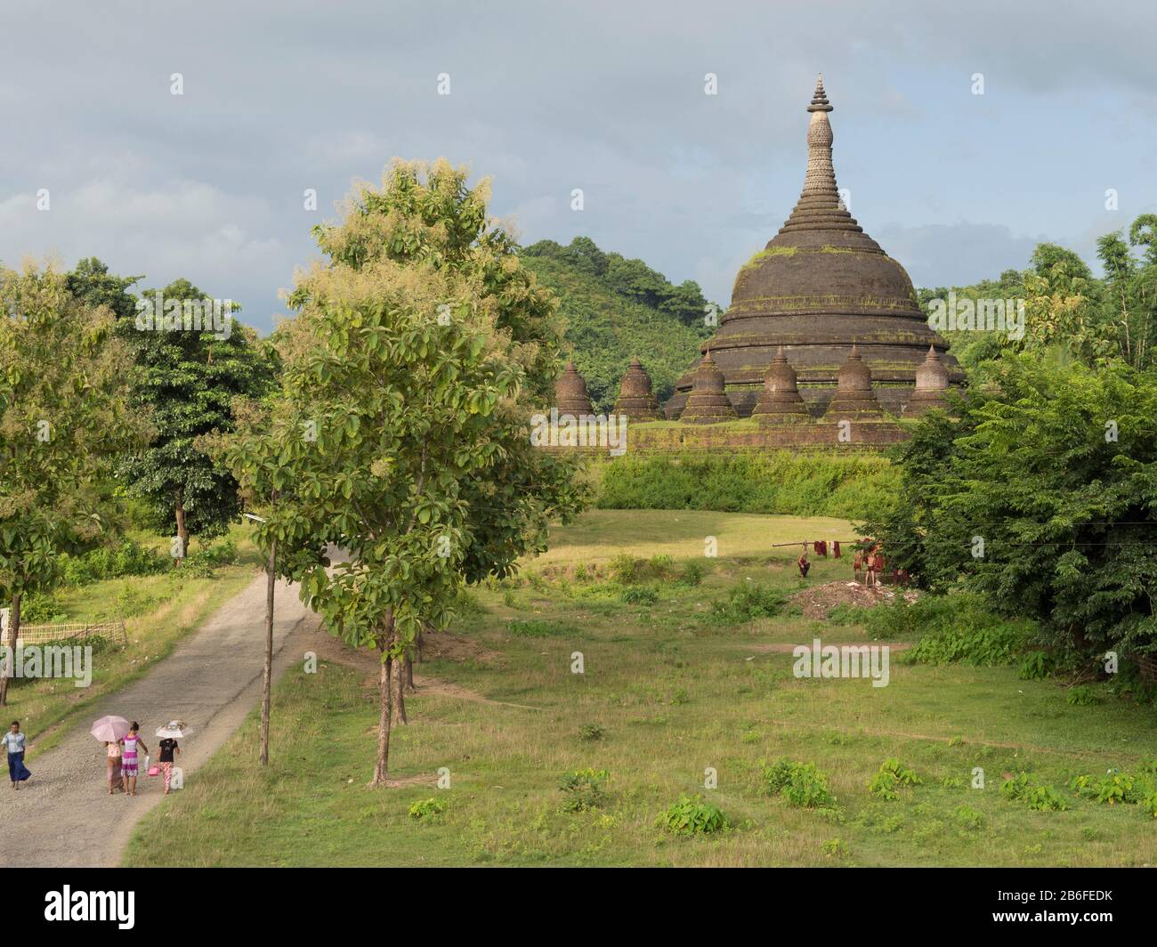 Trois femmes et un homme sur la route près du temple d'Andaw-théin, Mrauk U, Etat de Rakhine, Myanmar Banque D'Images
