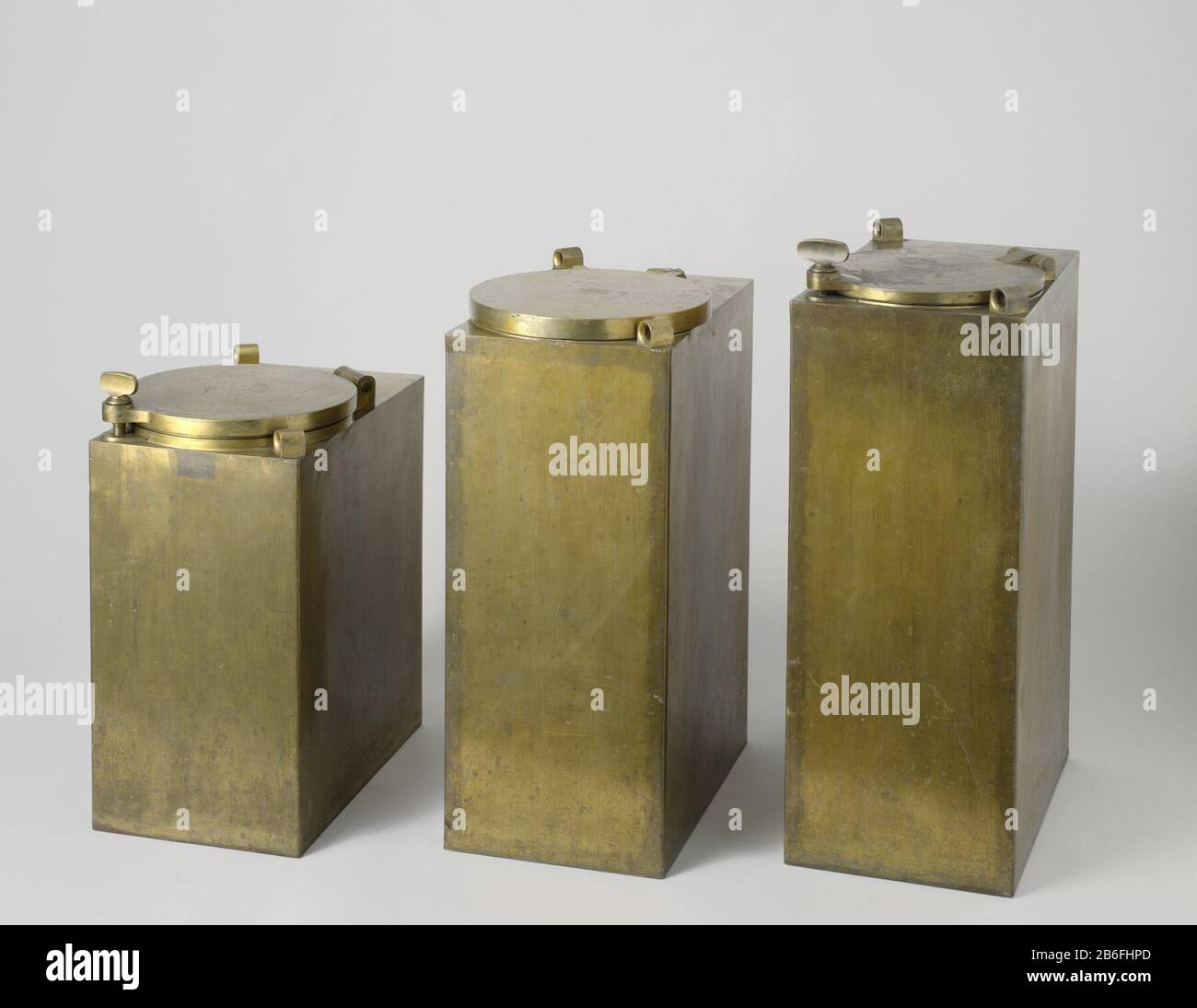 Buskruitkist, A-MC-1223-A Drie messing buckruitkisten van identieke rechthoekige base maar van verschillende hoogte. Bovenop hebben zij alledrie twee ogen, dans tegenover elkaar liggende hoeken geplaatst, en de sluting. De sluitingen zijn telkens van een ander type. De kleinste kist heeft een dubbele sluting geerkt 1, Banque D'Images