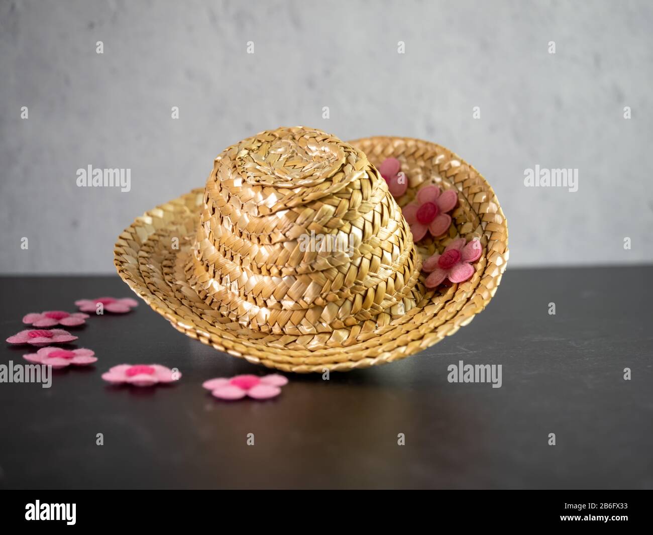 Chapeau de paille aux fleurs roses sur fond d'ardoise noire et de plâtre.  Accessoires et décoration maison en un seul ! Photo Stock - Alamy