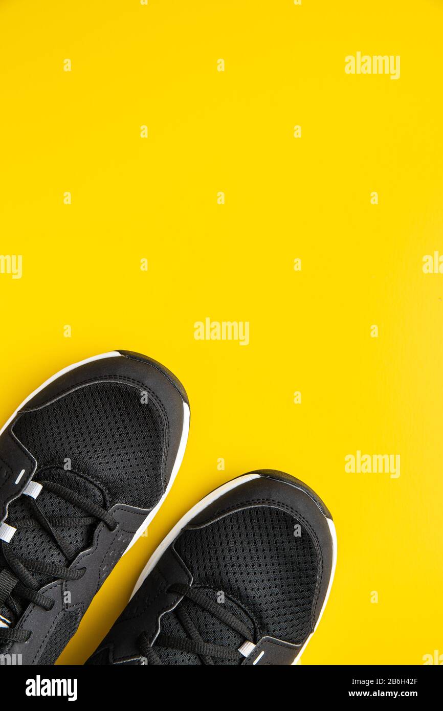 Chaussures de sport noires sur fond jaune. Vue de dessus. Banque D'Images