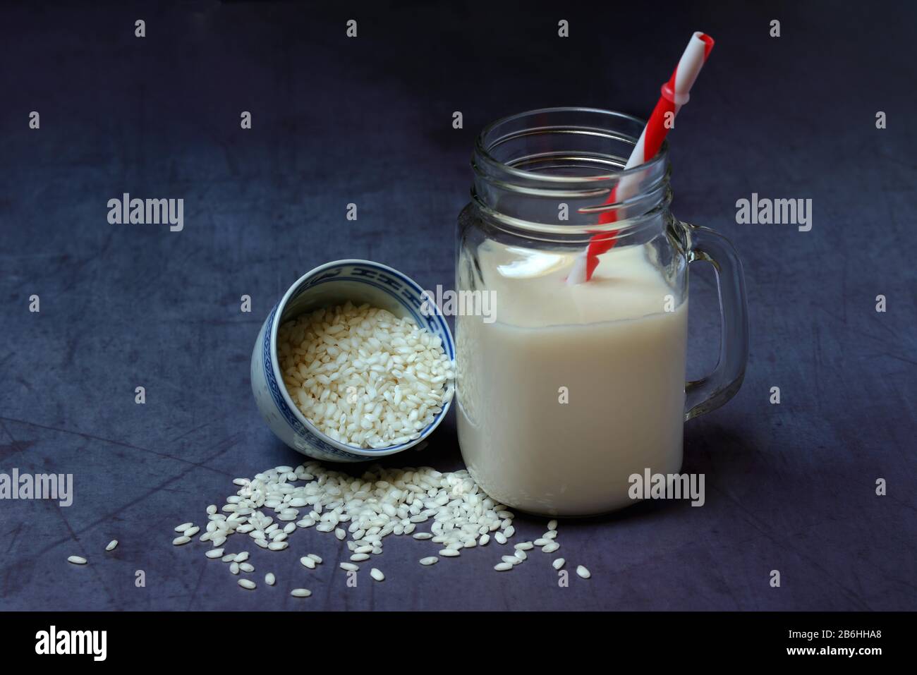 Lait de riz en verre avec paille à boire et grains de riz, Allemagne Banque D'Images