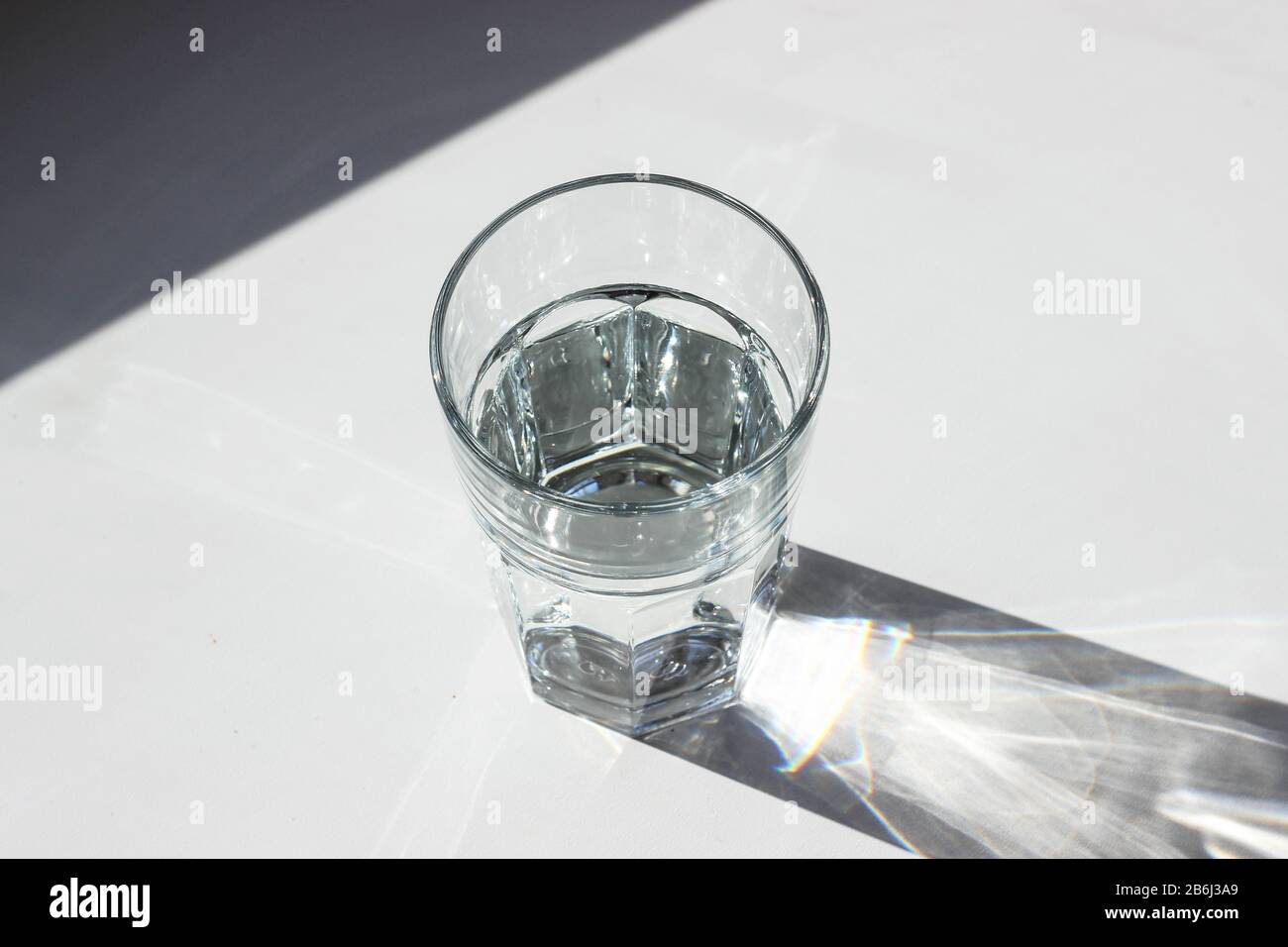 Verre de l'eau avec des ombres sur fond blanc Banque D'Images