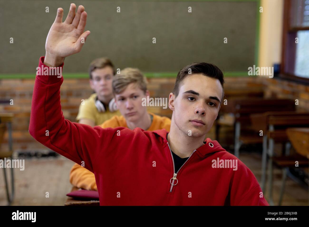 Vue de face de l'étudiant levant la main en classe Banque D'Images
