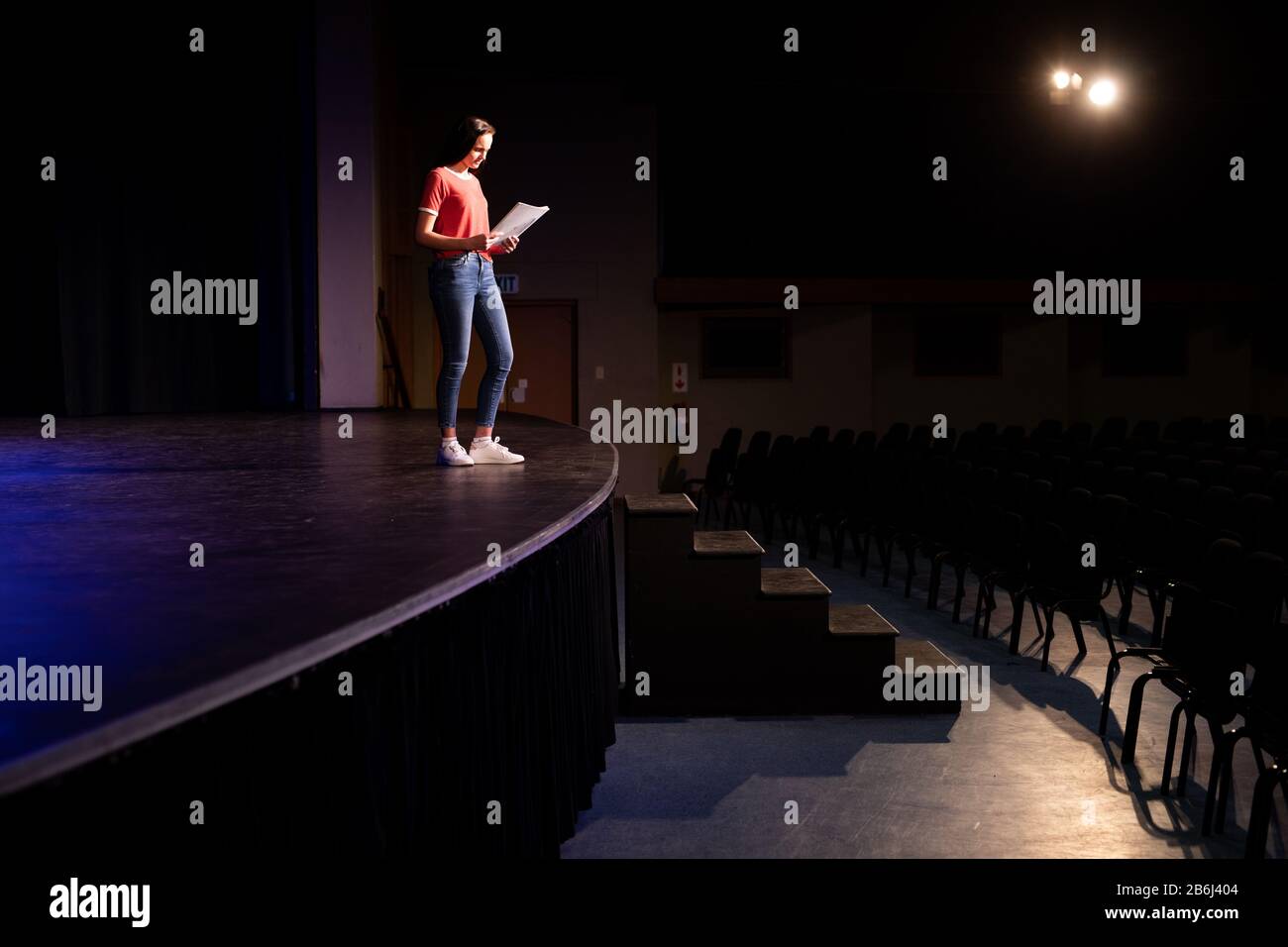 Vue latérale de l'étudiant qui lit un texte dans un théâtre Photo Stock -  Alamy