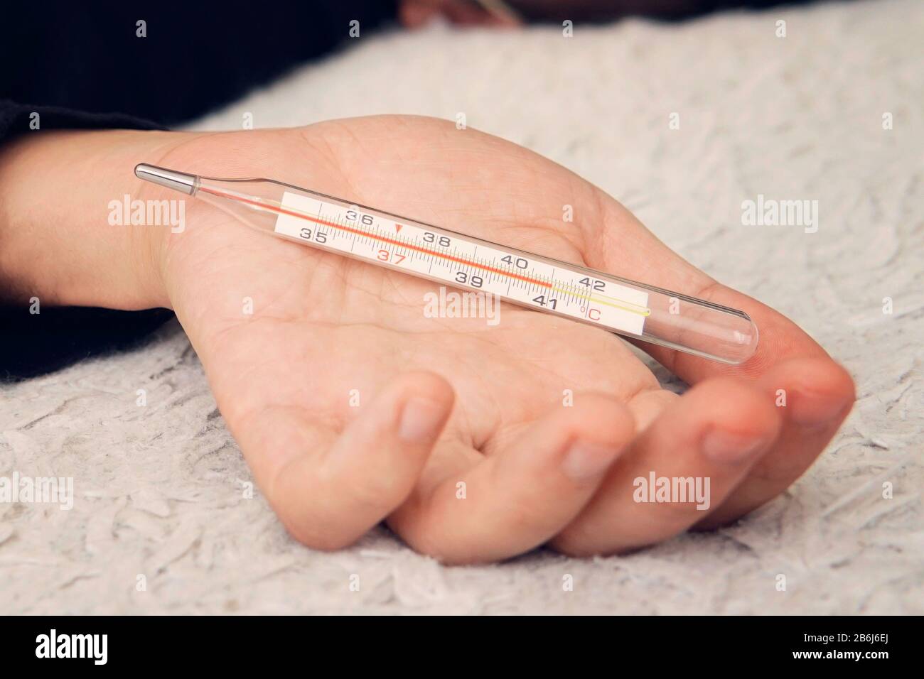 la main mâle tient un thermomètre. Le concept des rhumes et de la grippe. Thermomètre au mercure. Gros plan. Banque D'Images