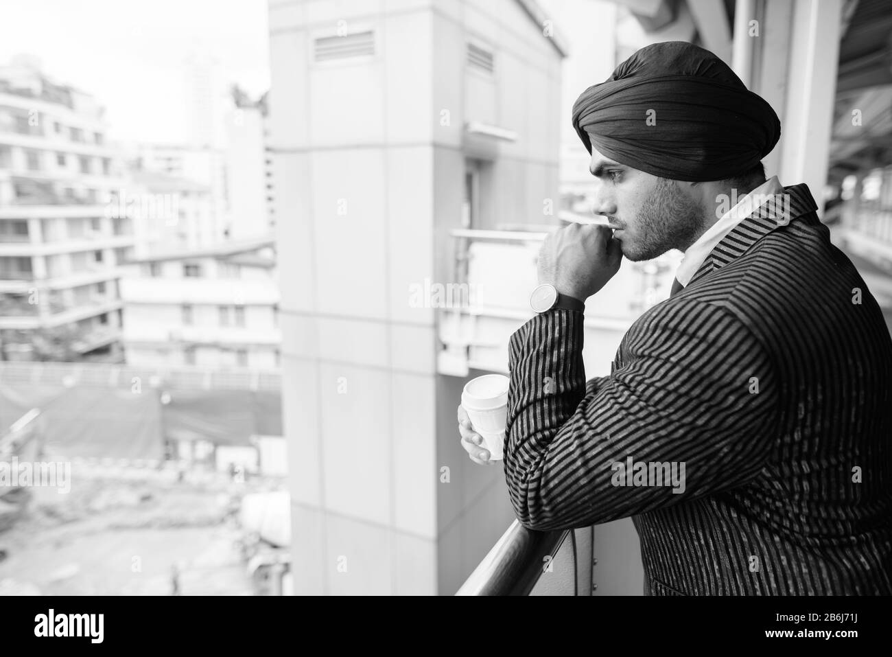 Jeune homme d'affaires sikh indien beau contre la vue du site de construction Banque D'Images