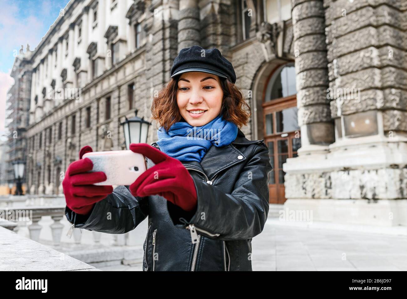 Portrait d'une jolie fille dans une veste en cuir qui fait du selfie sur un  smartphone dans la rue de la vieille ville d'europe Photo Stock - Alamy