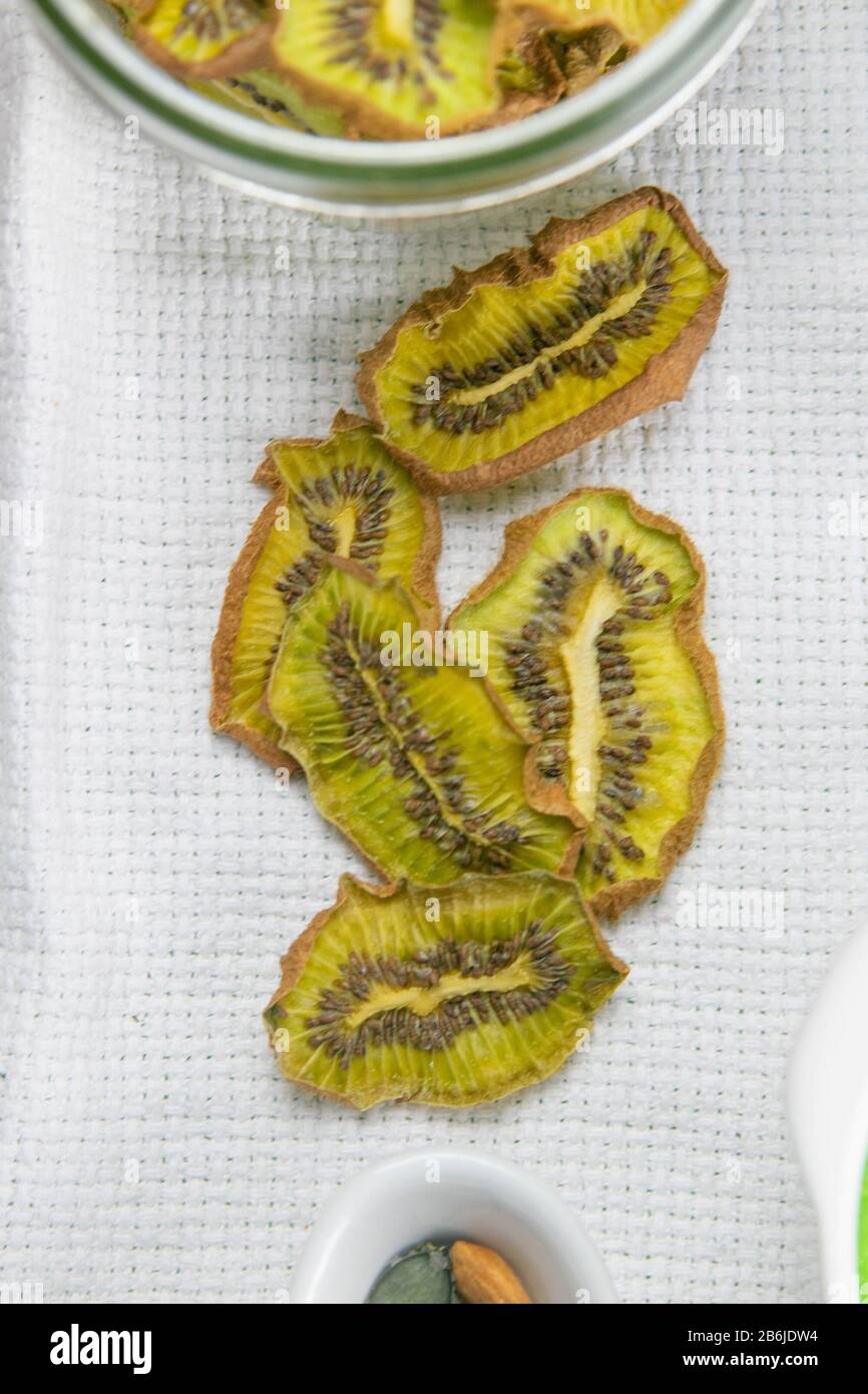 Collation saine. Chips de fruits déshydratés maison sur fond gris. Kiwi sec Banque D'Images