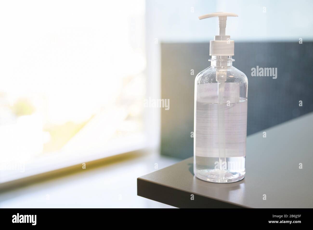 Flacon de pompe à gel d'alcool transparent à utiliser pour le lavage des mains placé sur la table, empêchant les germes de protéger le virus Covid-19, les soins de santé au bureau, salle de réunion. Banque D'Images