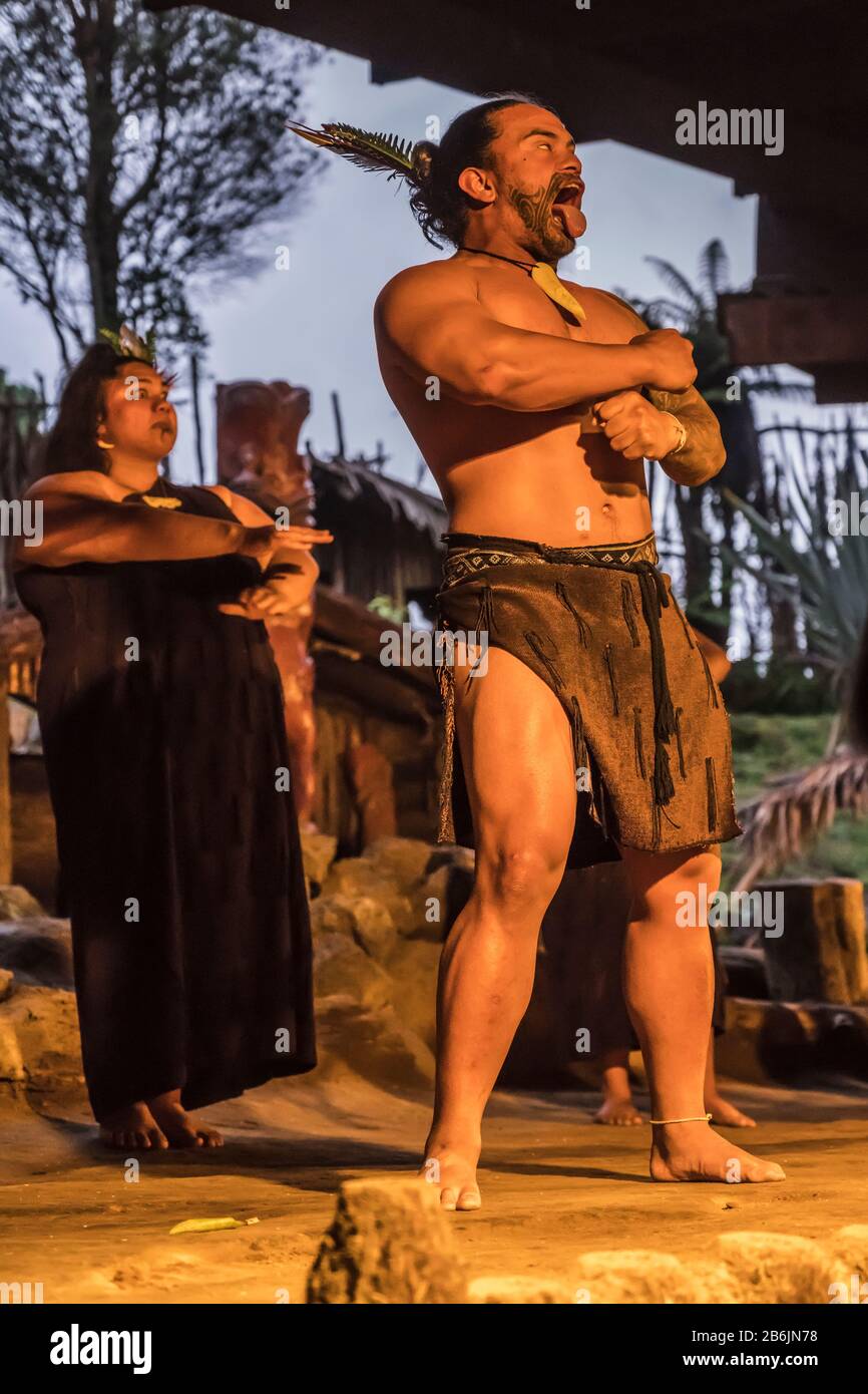 Rotorua, NOUVELLE-ZÉLANDE - 10 novembre 2019: Acteur dans les grimaces de robe traditionnelle exécutant la danse de guerre de Haka sur scène, tourné au Village maori Mitai performa Banque D'Images