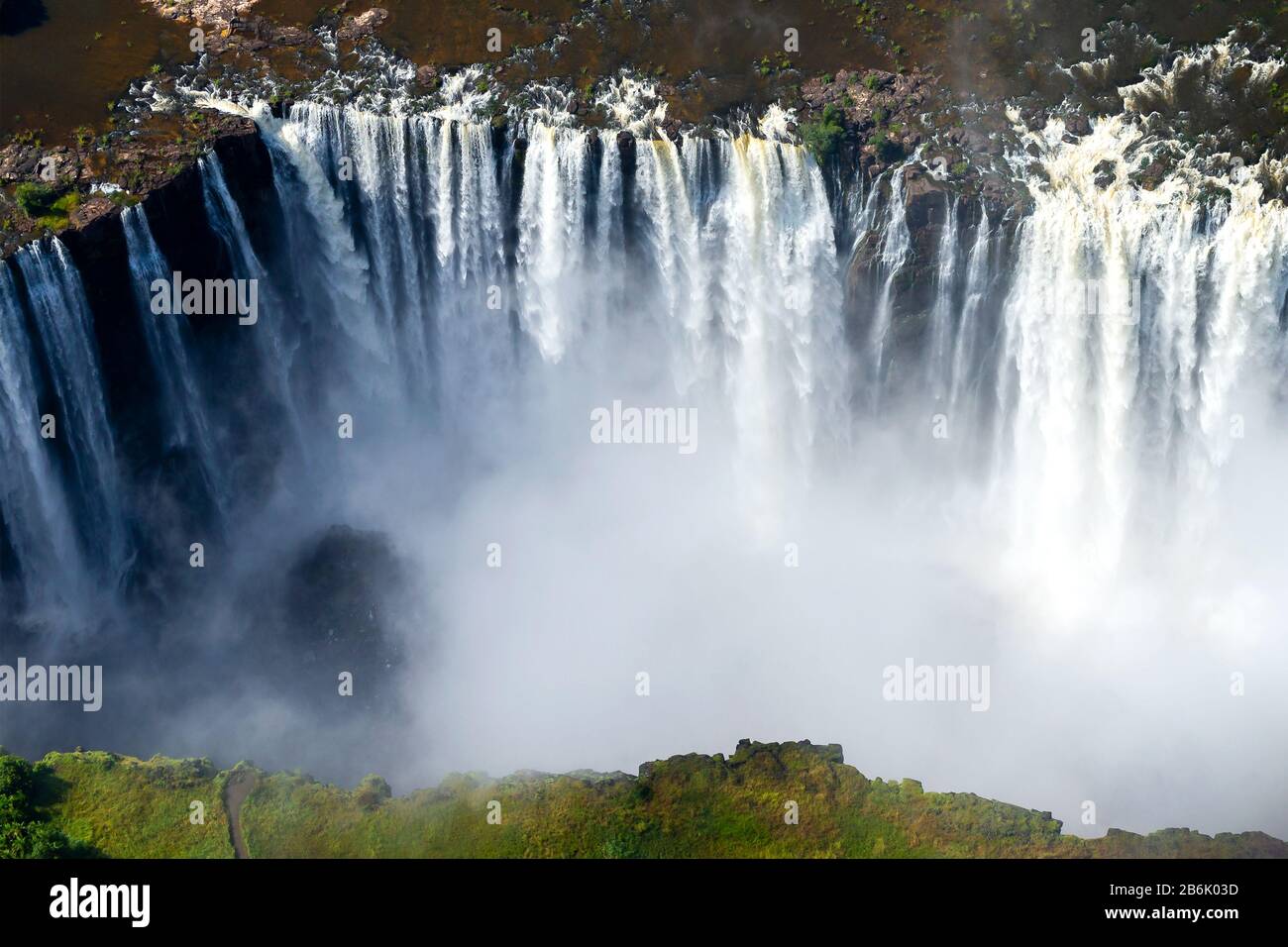 Victoria Falls vue aérienne à la frontière du Zimbabwe et de la Zambie en Afrique avec un volume impressionnant d'eau qui coule. Brouillard d'eau de la cascade. Banque D'Images