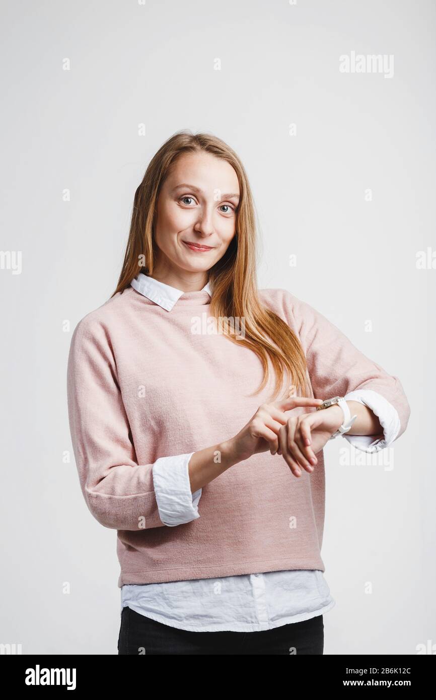 Jeune femme cadre regardant la montre-bracelet sur fond blanc Banque D'Images