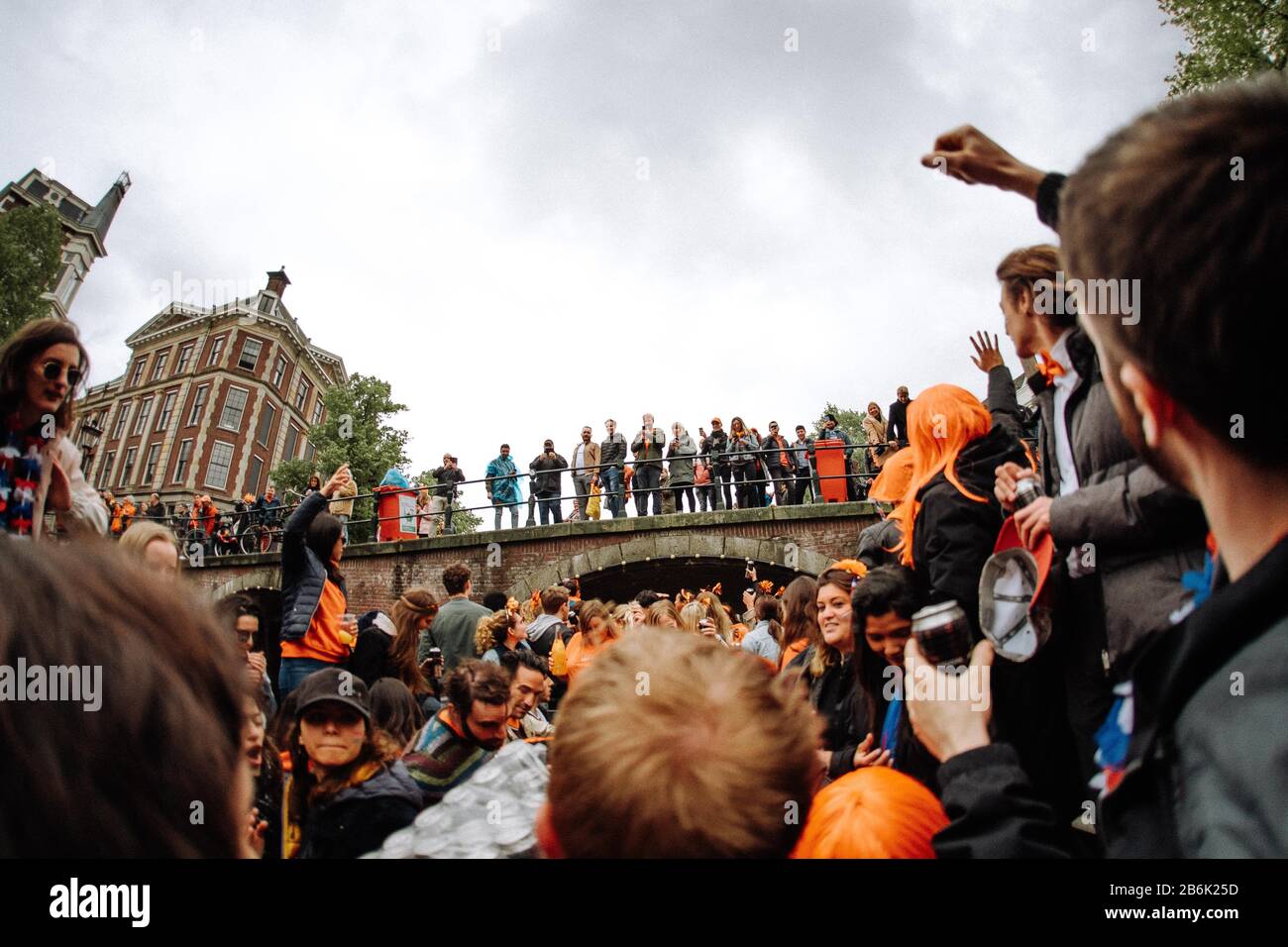 Les amateurs de fête d'Orange prennent le contrôle des canaux d'Amsterdam sur leurs bateaux de fête pour célébrer l'anniversaire du roi sur Koningsdag. Banque D'Images