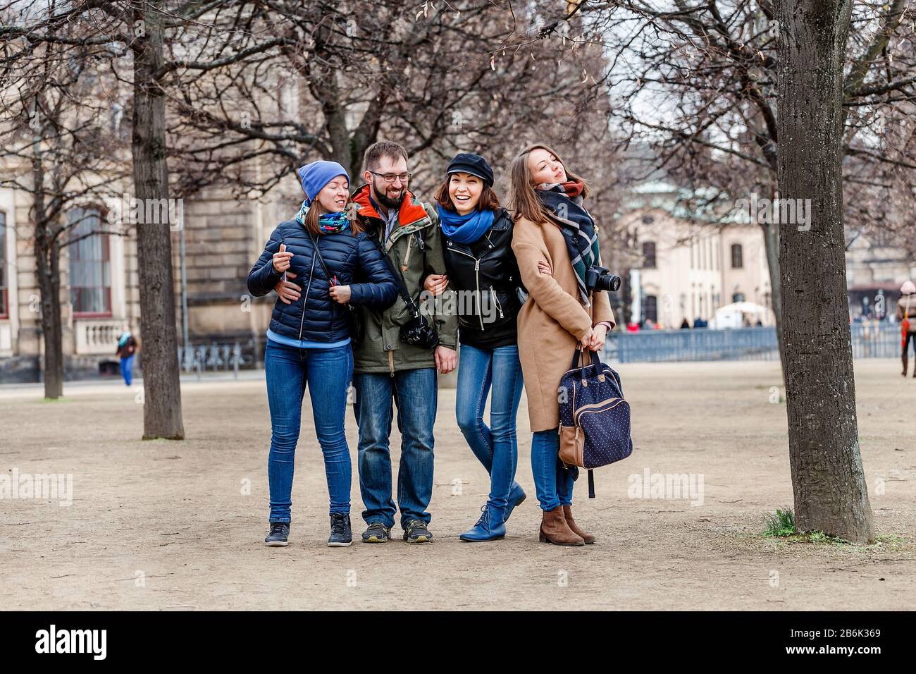 Une équipe de quatre amis heureux étudiants hople et rires dans le parc d'une ville européenne en hiver, concept de voyage Banque D'Images