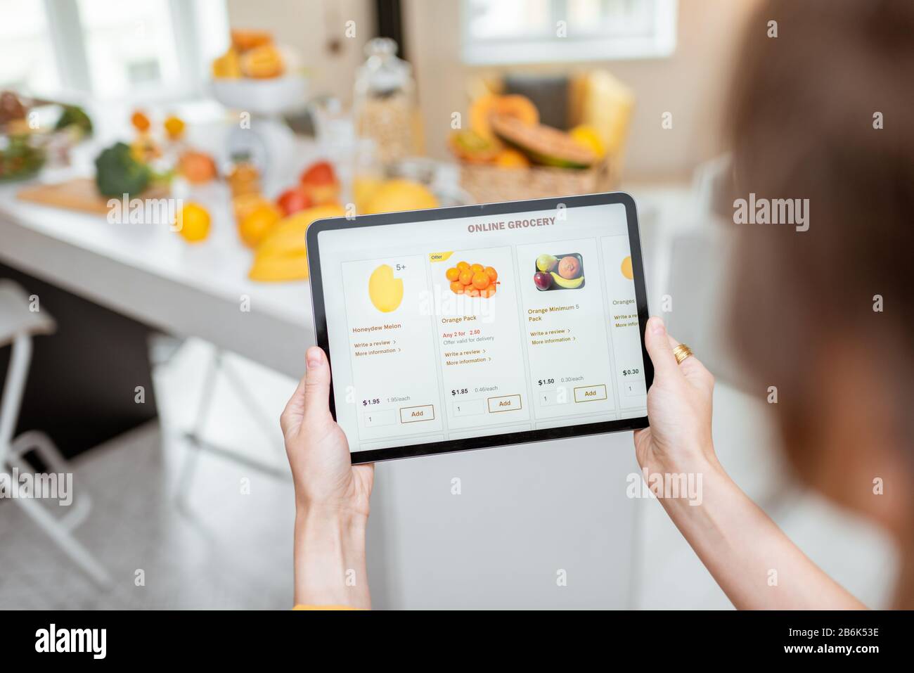 Femme faisant des achats de nourriture en ligne à l'aide d'une tablette numérique dans la cuisine, vue rapprochée sur un écran de tablette. Concept d'achat en ligne à l'aide d'appareils mobiles Banque D'Images