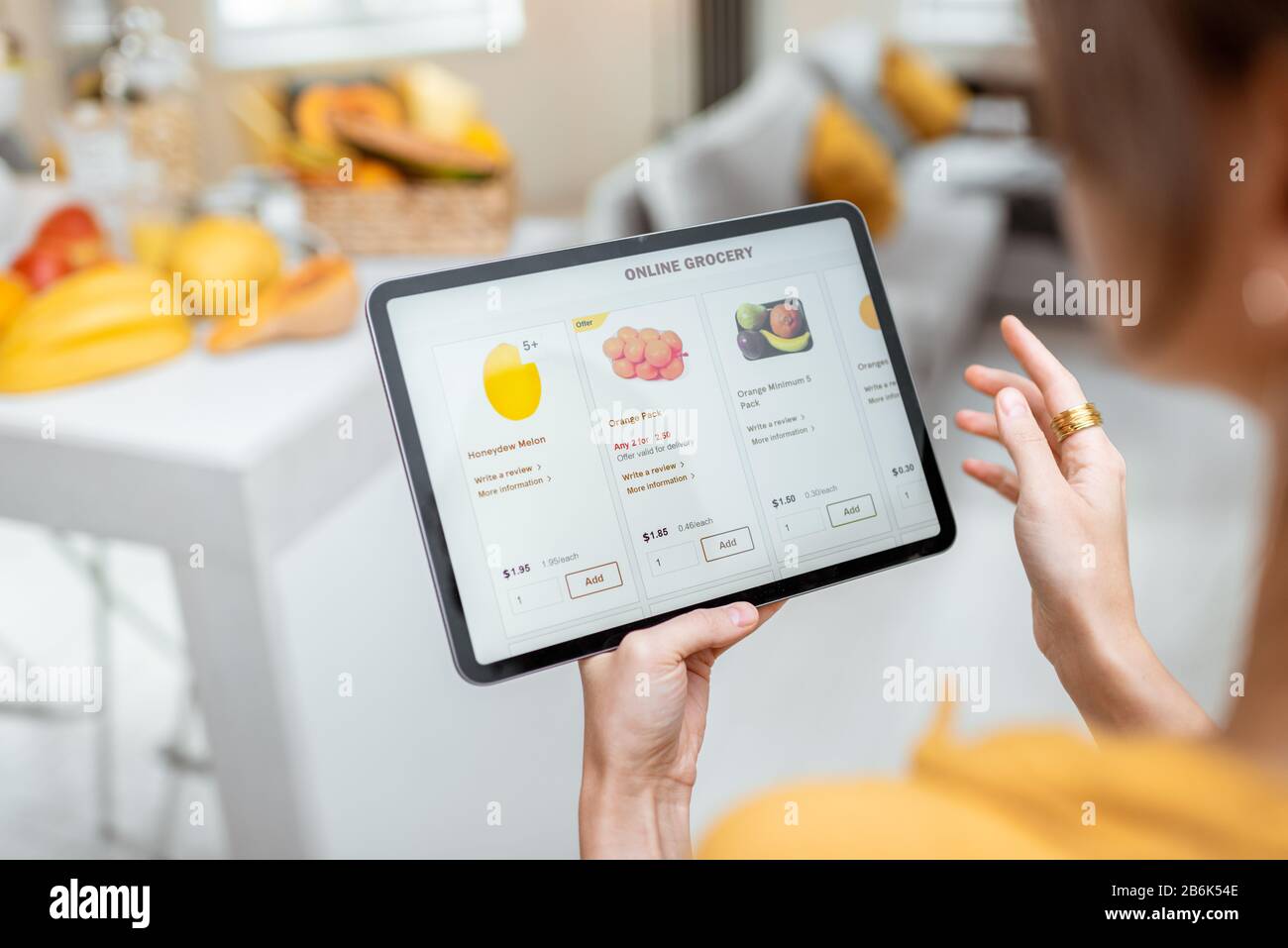 Femme faisant des achats de nourriture en ligne à l'aide d'une tablette numérique dans la cuisine, vue rapprochée sur un écran de tablette. Concept d'achat en ligne à l'aide d'appareils mobiles Banque D'Images