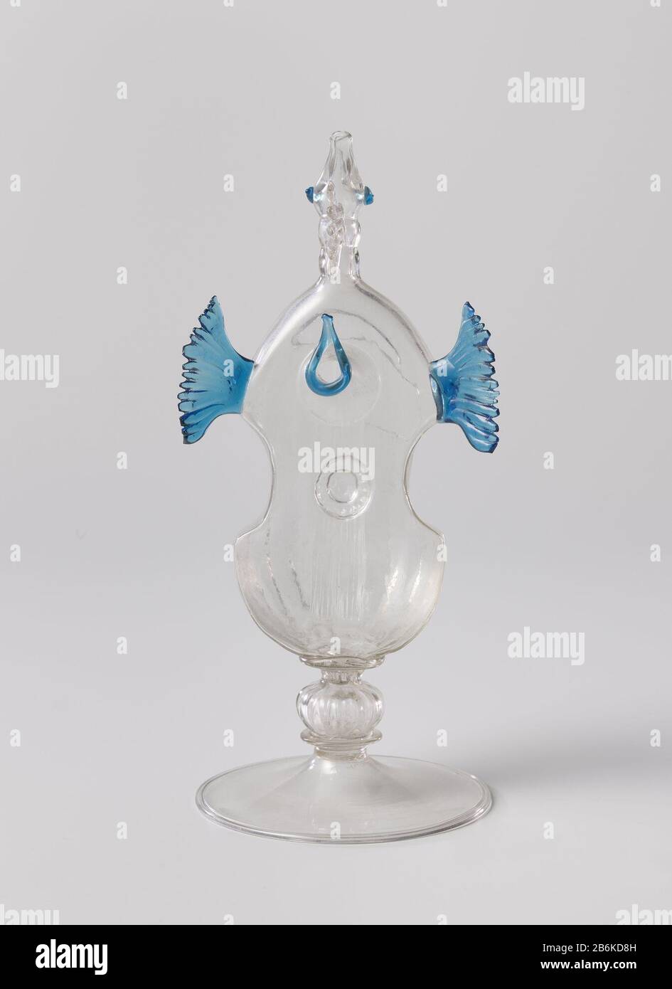 Verre à boire sous forme d'un instrument à cordes Platte voet met omgeslagen rand. De stam opgebouwd uen holle, geribde nodus boven een platte schijf. Het lichaam à de vorm van een snaarinstrument. Boven het Blauw omrande klankgat twee blauwe vleugels. Licht ingesnoerde hals uitlopend in een vogelkop met een kleurloze kam en geopende bek. Fabricant : glasblazer: AnoniemPlaats fabrication: Venetië Dating: CA. 1600 - env. 1700 kenmerken physique: Helder, kleurloos en verre matériau: Glas Techniek: Glasblazen Dimensions: H 21,2 cm. × d 9,4 cm. Banque D'Images