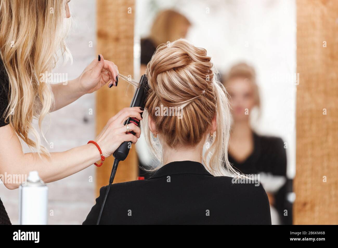 femme d'affaires chef de salon de beauté faisant coiffures et regardant le miroir Banque D'Images
