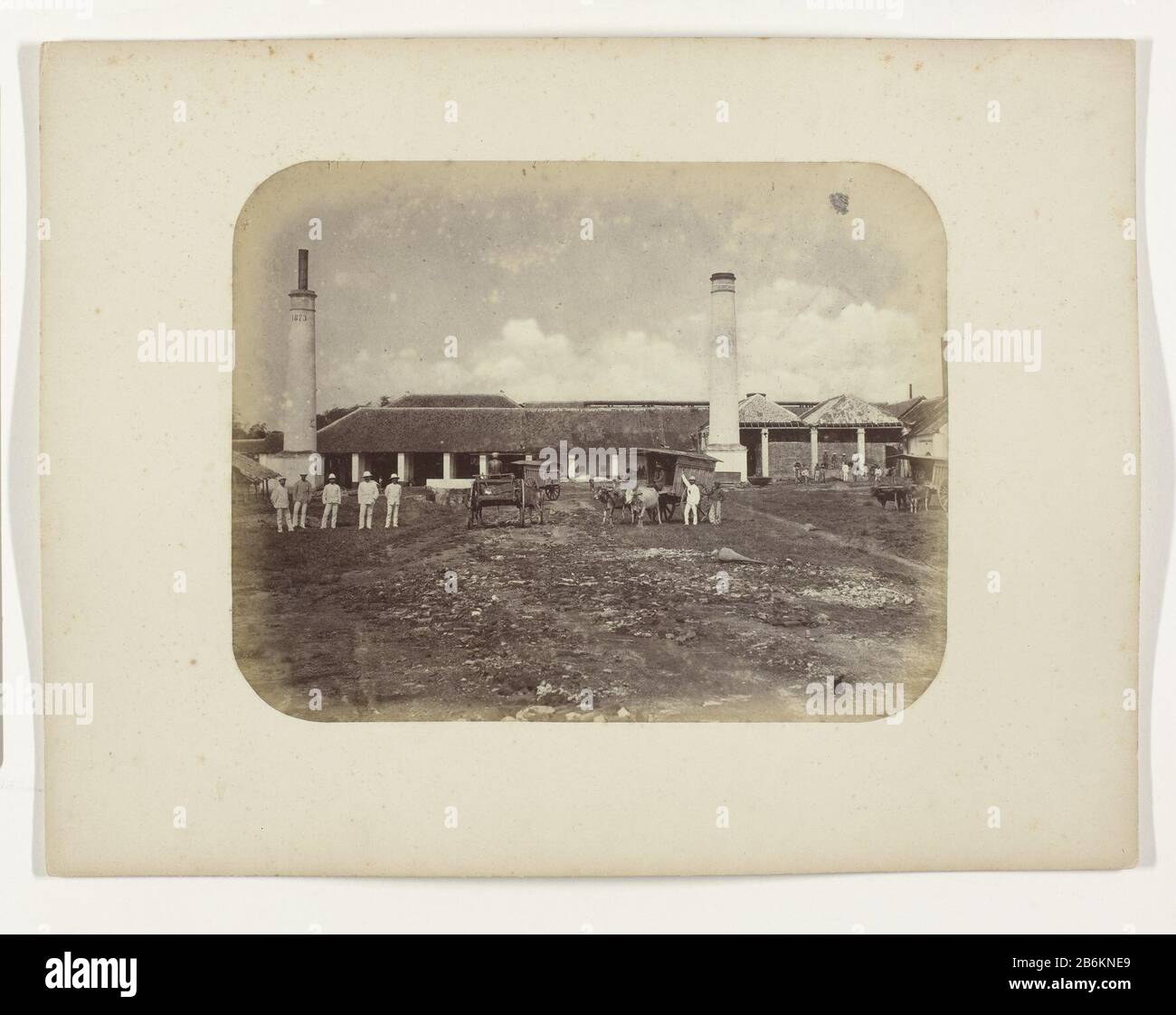 Une fabrique de sucre avec deux cheminées, à gauche en 1873. Au premier plan à gauche se trouvent cinq Européens. Au milieu se trouvent trois charrettes à boeufs avec des indigènes et des Européens et un charrette droite avec quelques indigènes en arrière-plan à l'usine. Une partie de l'album offert par l'Association Soerabayasche des fabricants de sucre à Frederick Beyerinck, résident de Soerabaja. Fabricant : Photographe: Herman Salzwedlopdrachtgever: Soerabayasche Association of Sugar Fabricant Lieu de fabrication: Surabaya Dating: 1876 - 1884 Caractéristiques physiques: Albumen print materiel: Paper technique: Albumen print di Banque D'Images