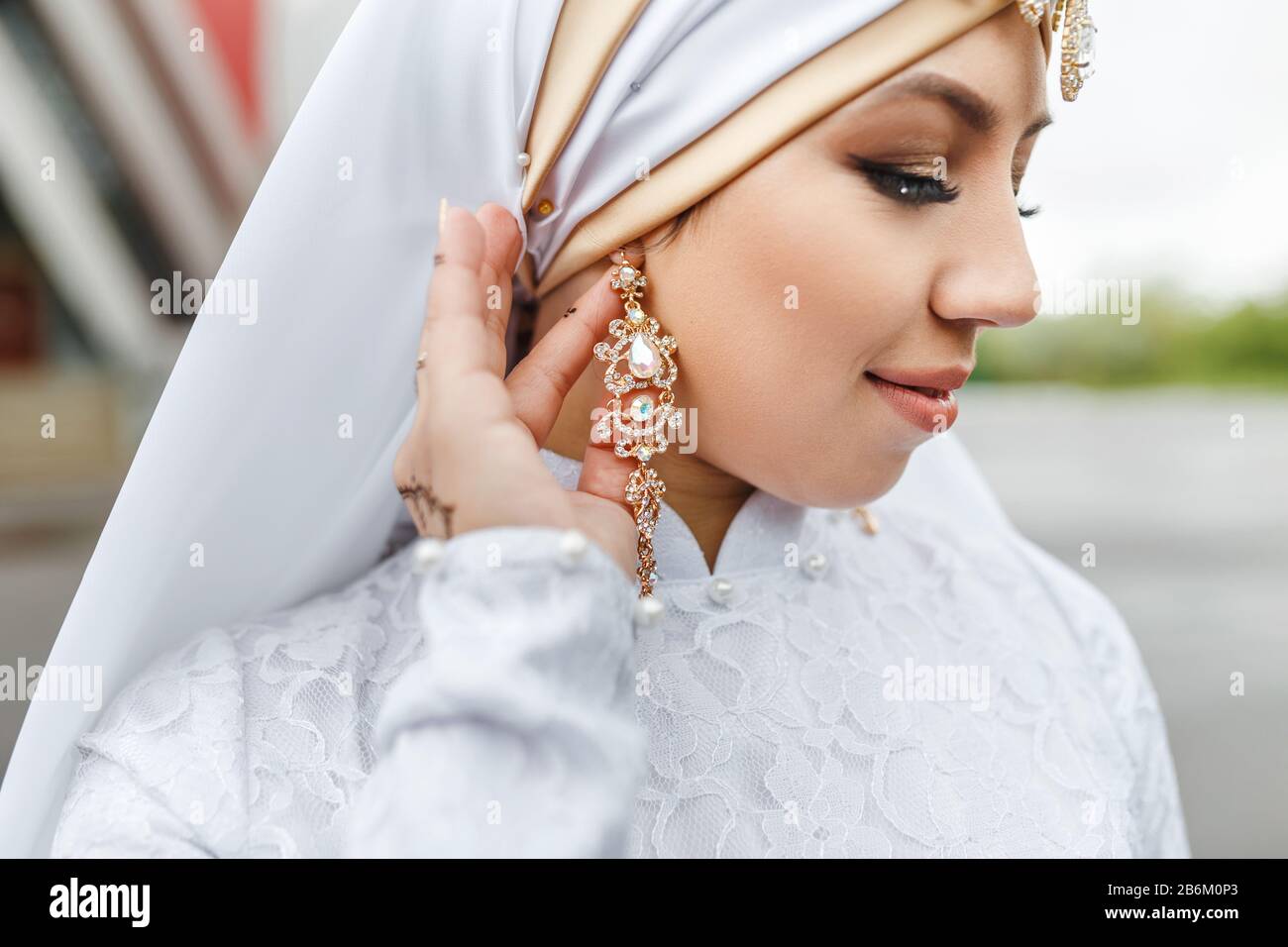 Charmante mariée musulmane arabe dans la robe de mariage nikah et le  foulard hijab, gros plan sur les bijoux et les boucles d'oreilles Photo  Stock - Alamy