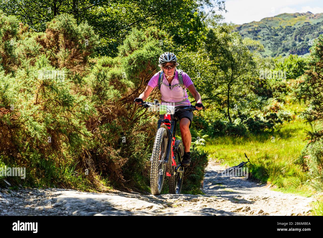 Cycliste (sur e-bike) sur l'ascension au-dessus de Knotts au-dessus De Little Langdale dans le district de English Lake Banque D'Images Cycliste (sur e-bike) sur l'ascension au-dessus de Knotts au-dessus De Little Langdale dans le district de English Lake Banque D'Images