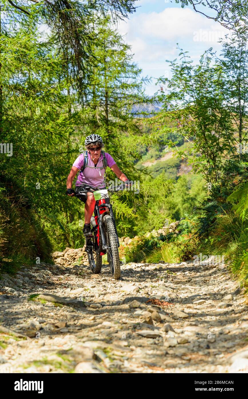 Cycliste (sur e-bike) sur piste rocheuse près de Stone chair Hill dans le district de English Lake Banque D'Images