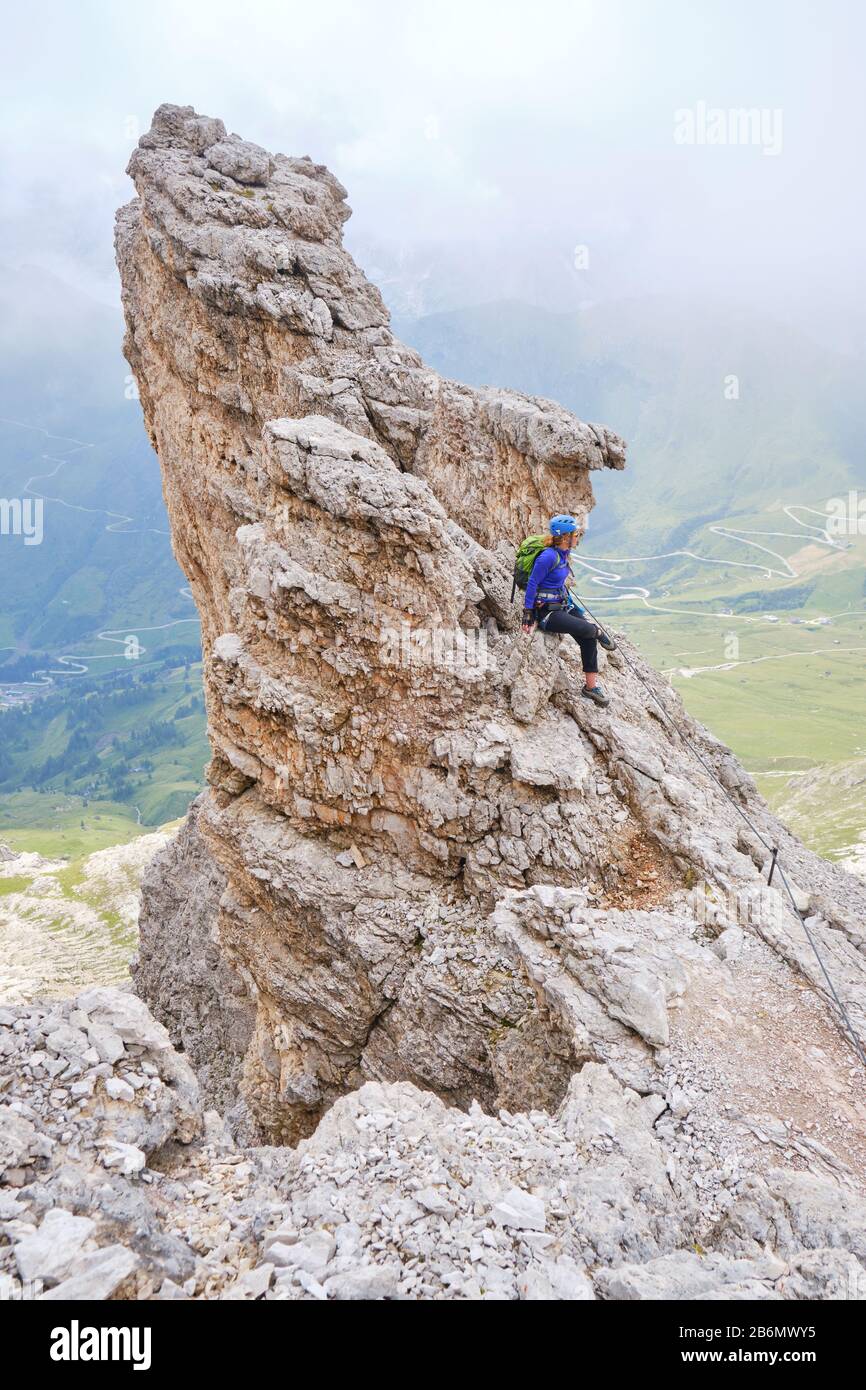 Femme se tient sur une formation de roche pointue, sur via ferrata Cesare Piazzetta, Dolomites montagnes, Italie. Concept pour des vacances actives dans les montagnes. Banque D'Images