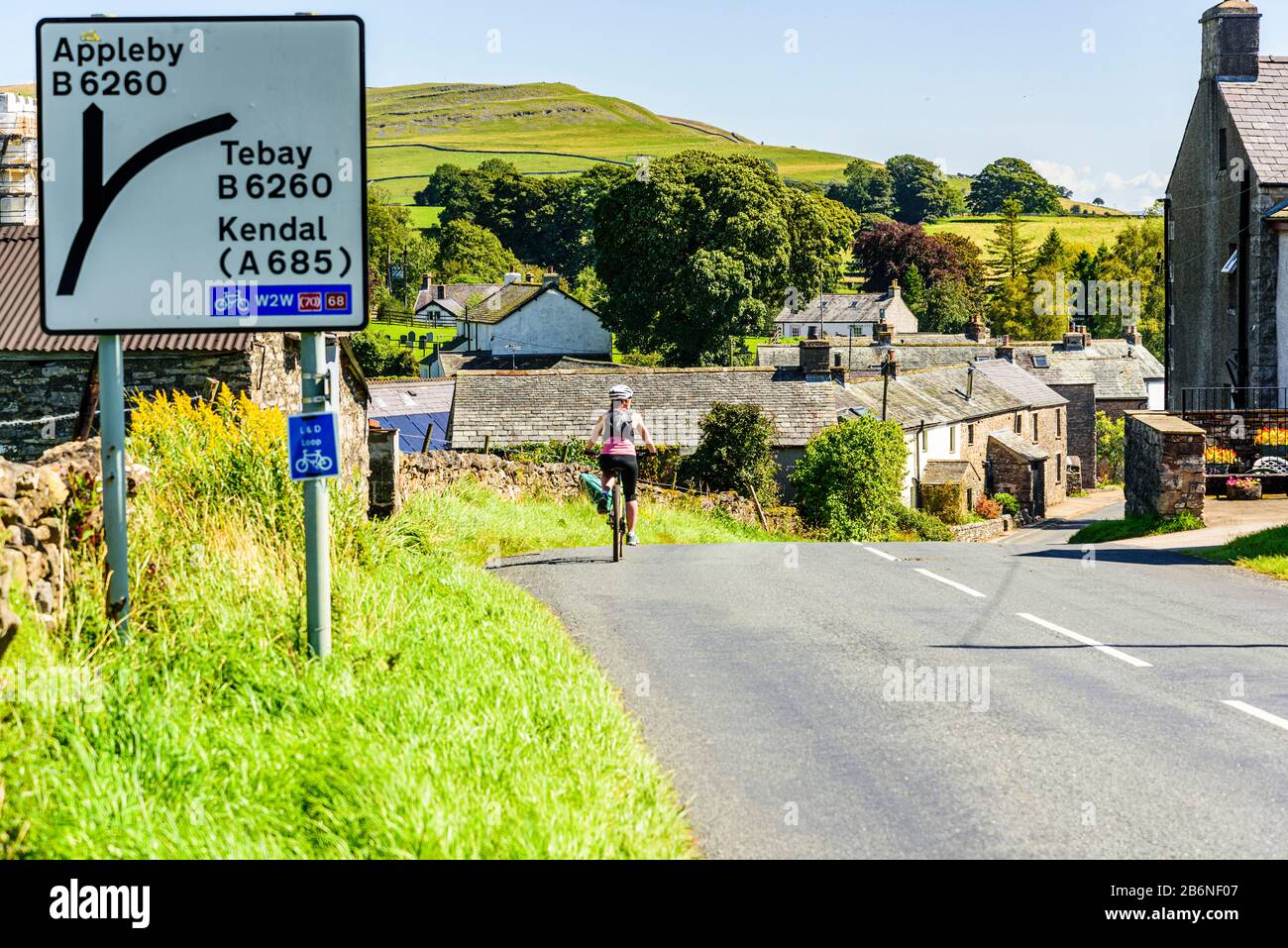 Cycliste descendant dans Orton dans le Yorkshire Dales National Park Banque D'Images Cycliste descendant dans Orton dans le Yorkshire Dales National Park Banque D'Images