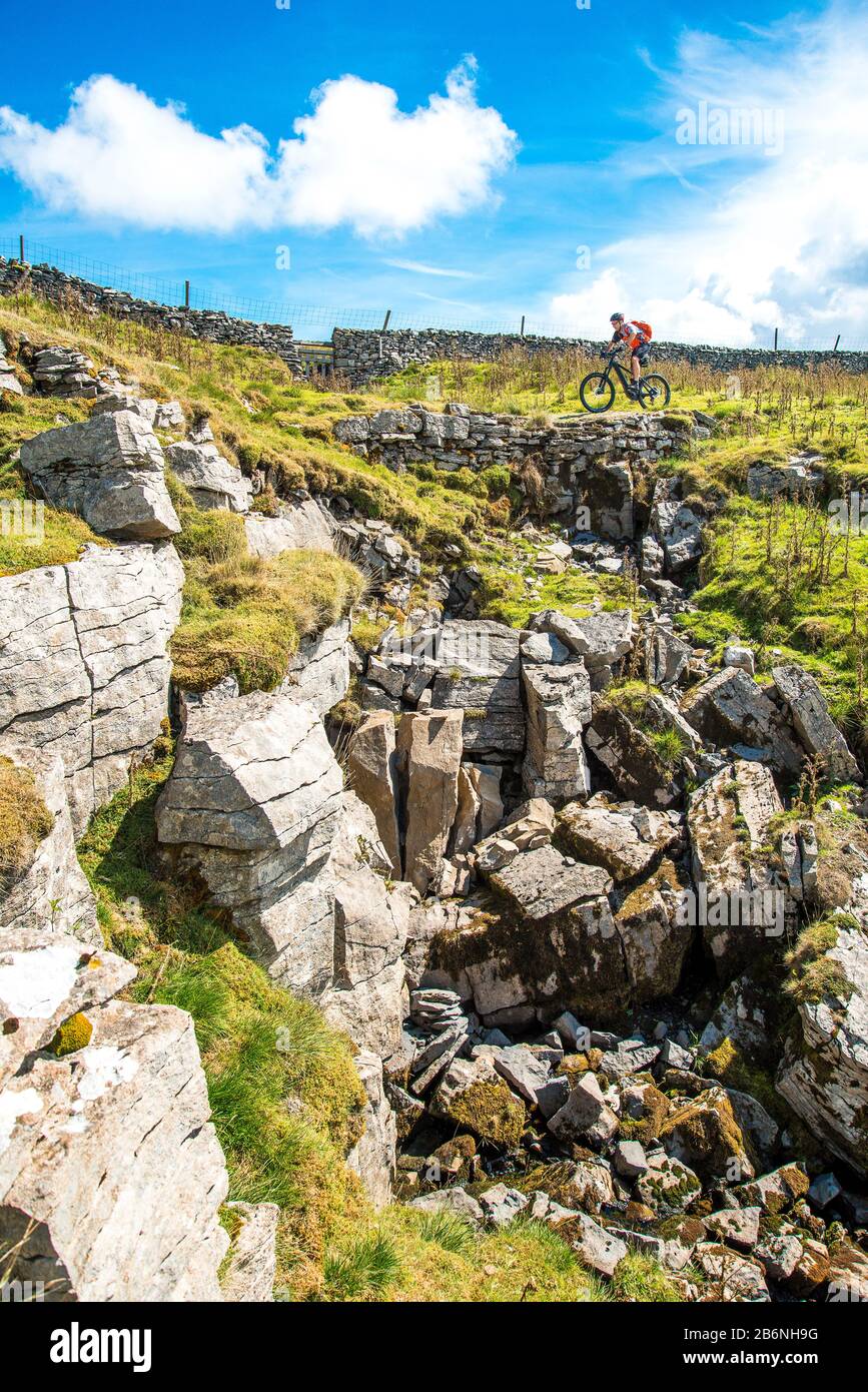 Cycliste (sur e-bike) sur la route De Conduite (Pennine Bridgleway) au-dessus de Dentdale dans le Yorkshire Dales Banque D'Images