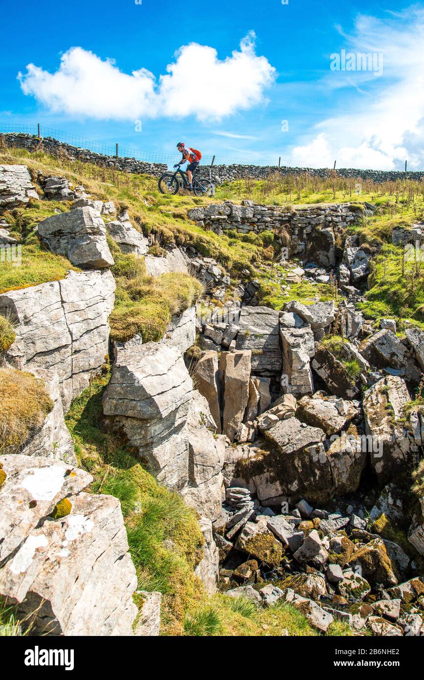 Cycliste (sur e-bike) sur la route De Conduite (Pennine Bridgleway) au-dessus de Dentdale dans le Yorkshire Dales Banque D'Images