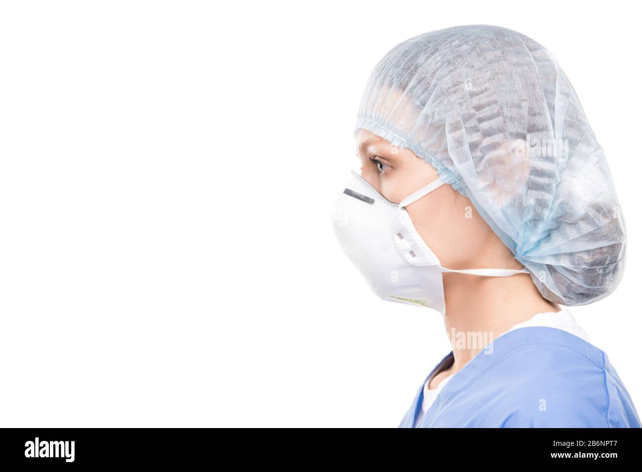 Vue latérale d'un spécialiste médical féminin dans le masque de protection et la casquette chirurgicale sur fond blanc Banque D'Images