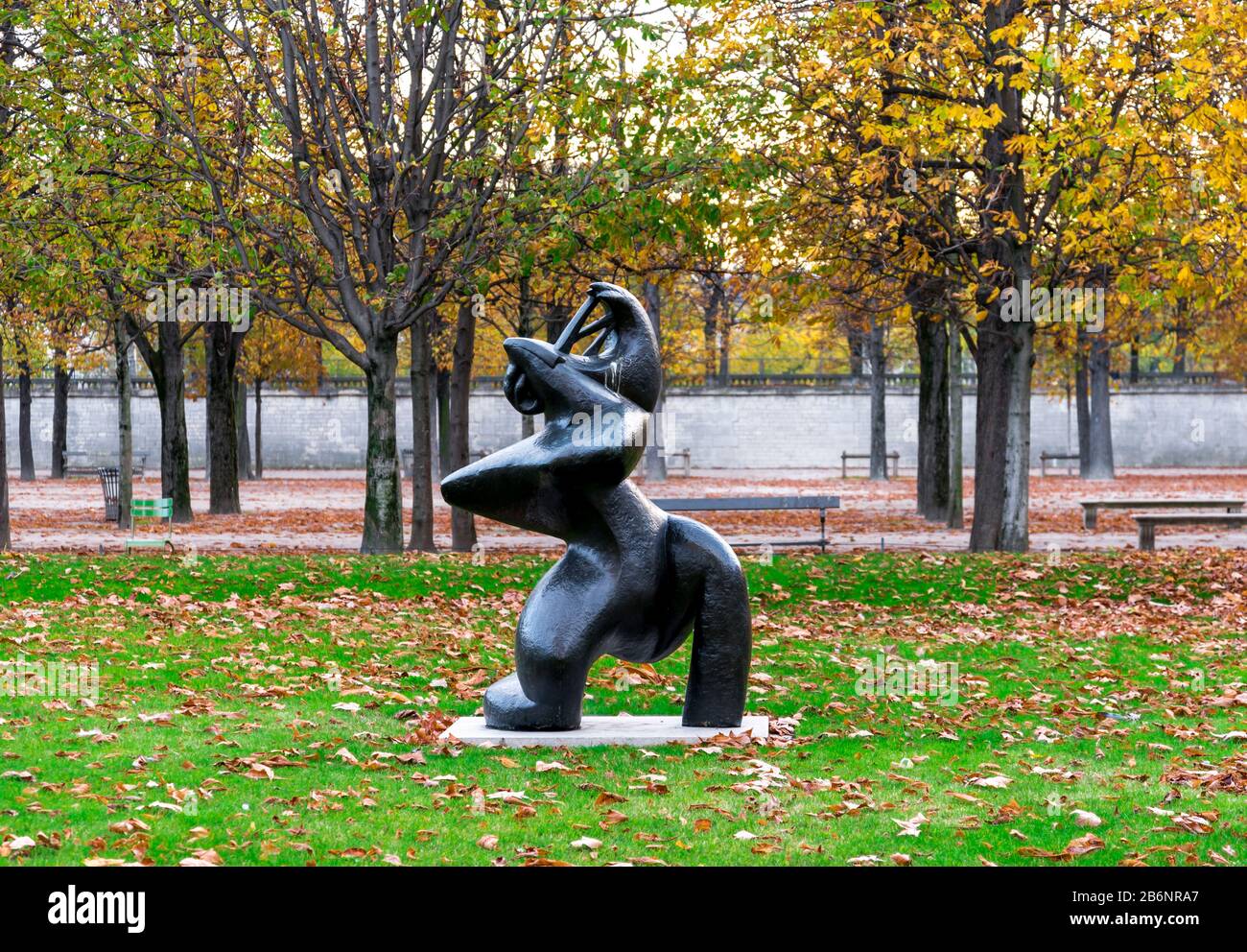 Une statue de bronze appelée « Grand musicien » avec beaucoup de feuilles tombées autour d'une pelouse dans le jardin des Tuileries, Paris, France. Banque D'Images