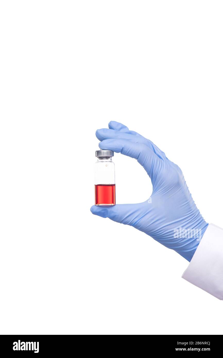 Gros plan d'un médecin non reconnaissable dans des gants chirurgicaux contenant une bouteille médicale de vaccin rouge sur fond blanc Banque D'Images