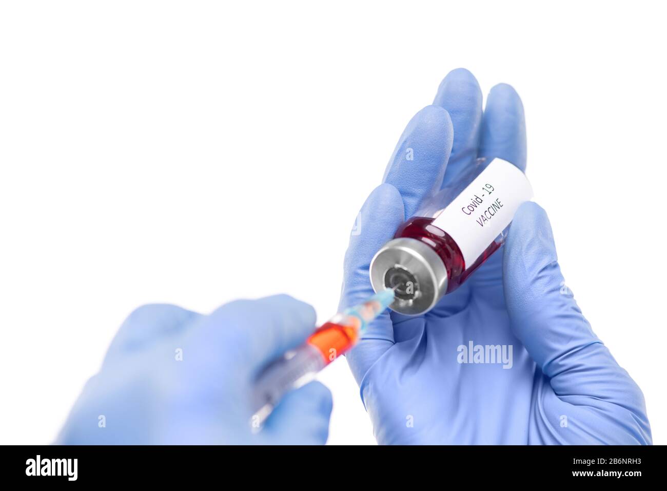 Gros plan de l'infirmière dans des gants chirurgicaux remplissant la seringue de vaccin contre le coronavirus, fond blanc Banque D'Images