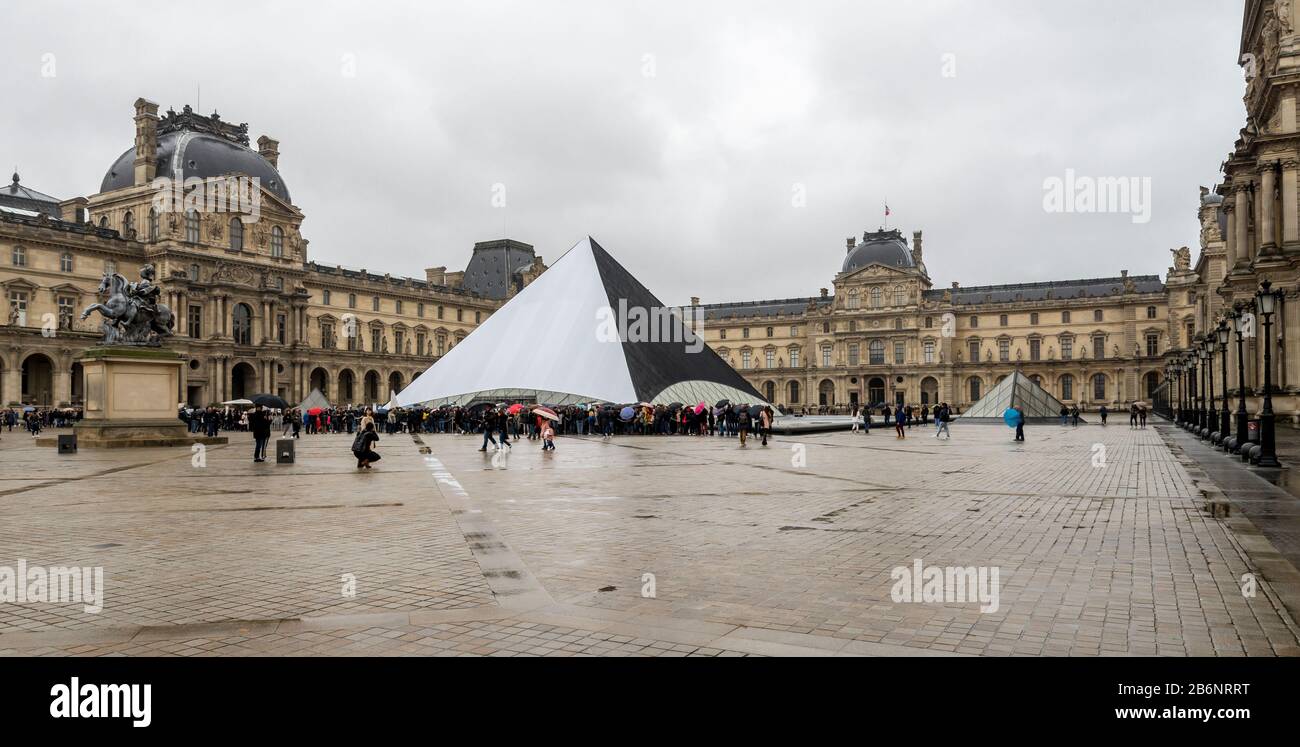Une place devant le musée du Louvre avec une grande pyramide et des visiteurs à l'entrée, Paris, France Banque D'Images
