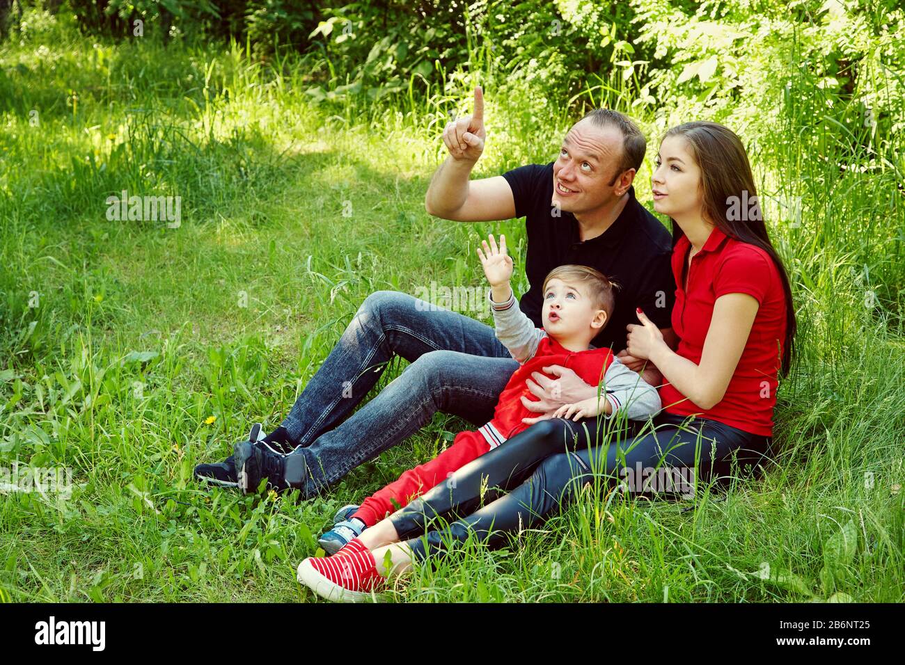 portrait extérieur d'une famille heureuse. Maman, papa et enfant à la recherche. Banque D'Images
