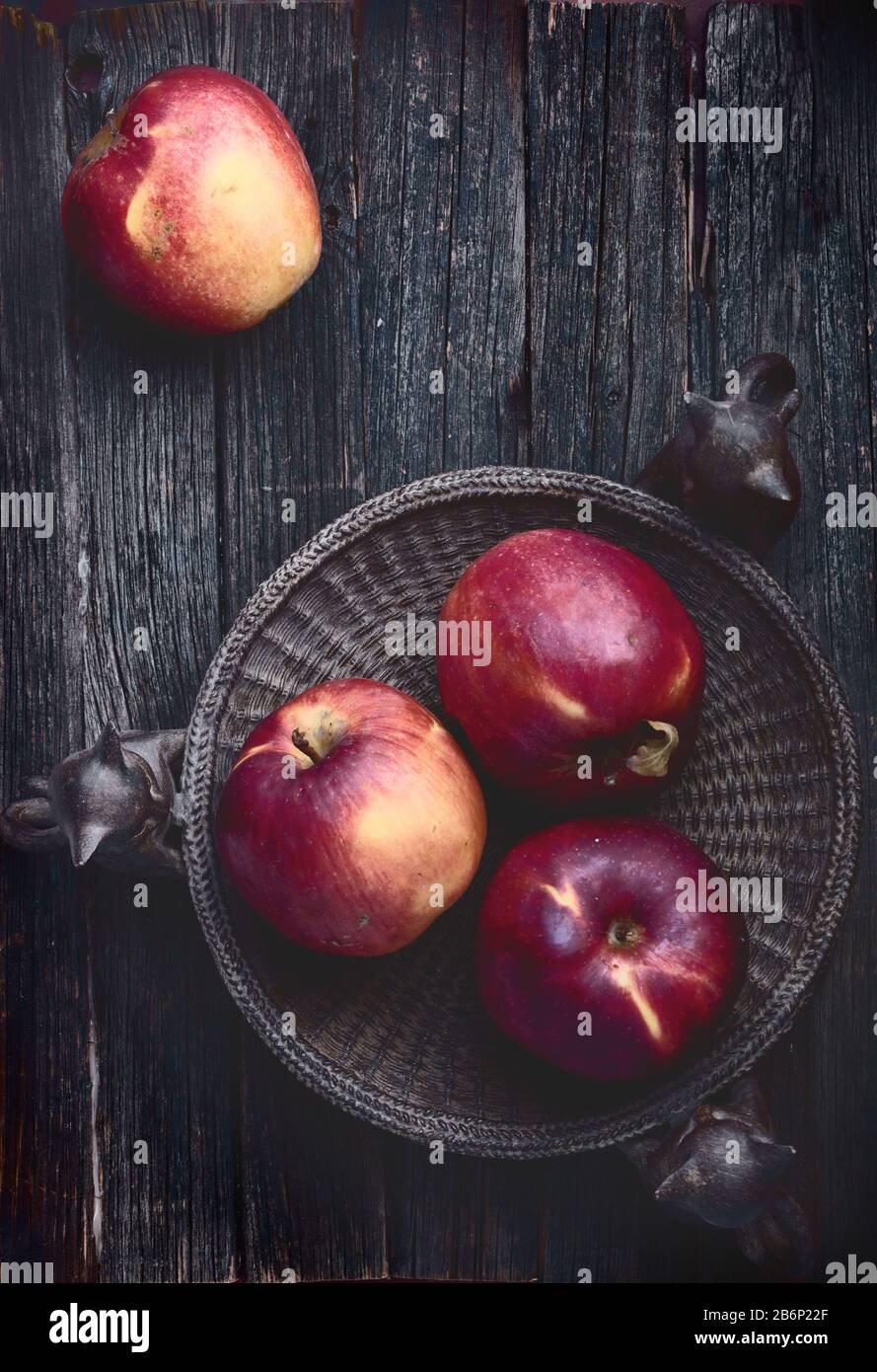 pommes rouges sur la vieille surface de table en bois rustique sombre, plantées, personne Banque D'Images