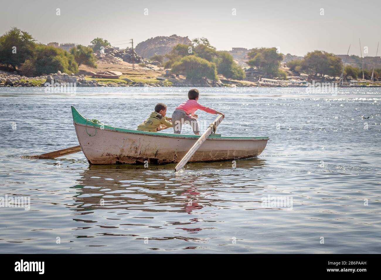 2 enfants rasant un bateau dans le Nil, Assouan Banque D'Images