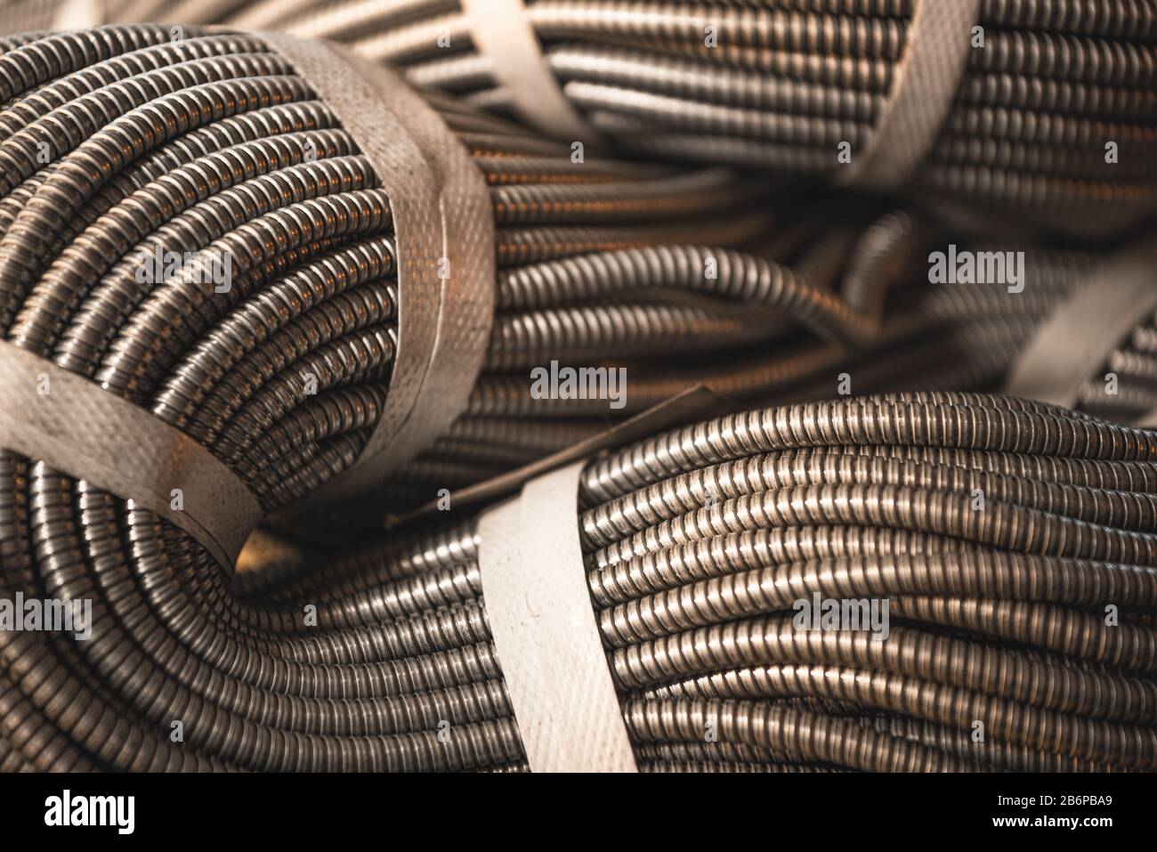 Gros plan d'un énorme paquet doré de tubes flexibles métalliques interconnectés dans une usine ou une usine. Le concept de production militaire et industrielle moderne Banque D'Images