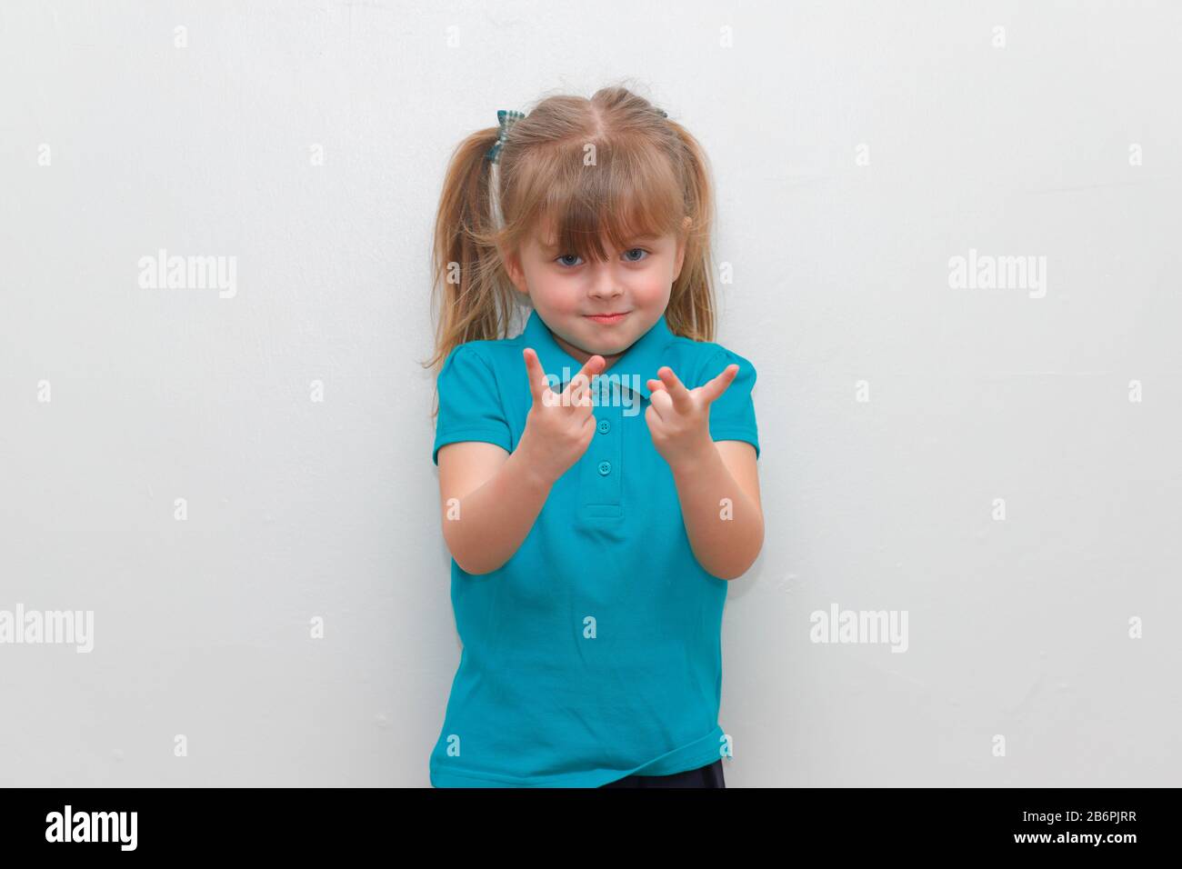 Une jeune fille de 4 ans qui colle 2 doigts vers le haut. Banque D'Images