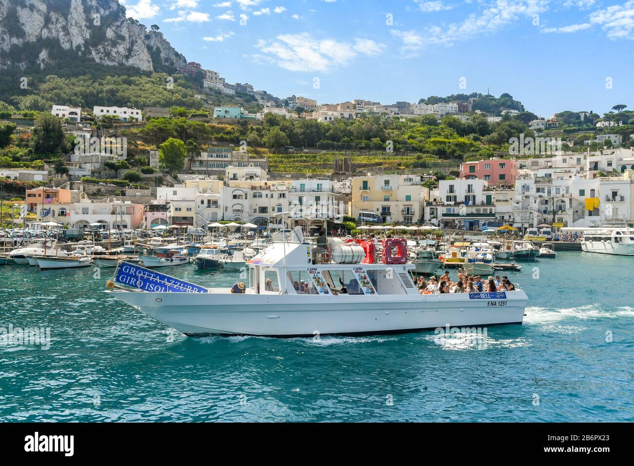 Île DE CAPRI, ITALIE - AOÛT 2019: Groupe de personnes à bord d'un bateau à moteur lors d'une excursion touristique à la Grotte bleue sur l'île de Capri. Banque D'Images
