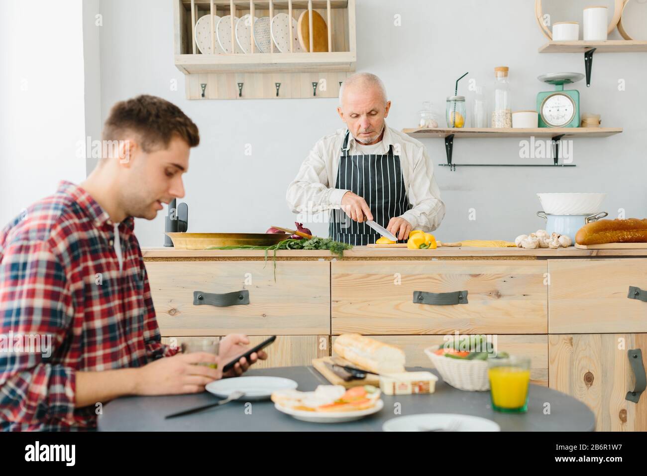 Jeune homme et son père cuisiniers dans la cuisine Banque D'Images