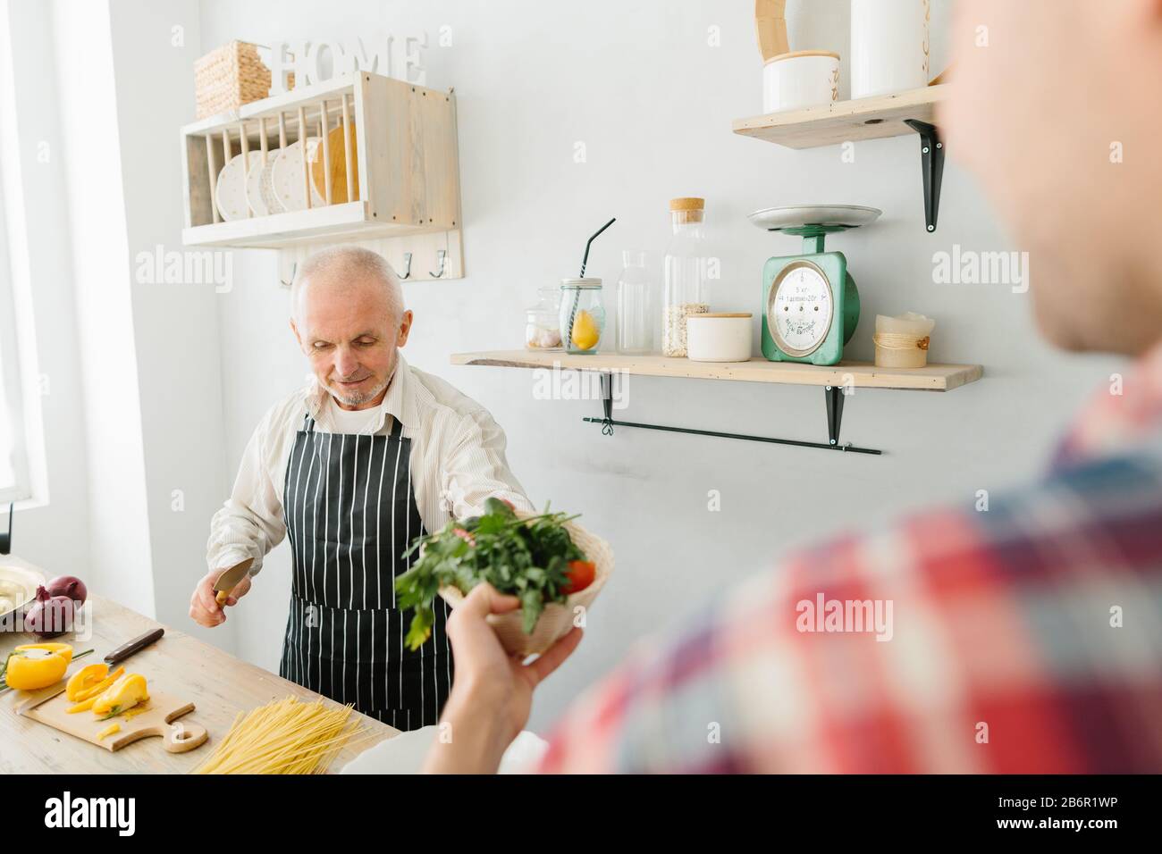 Jeune homme et son père cuisiniers dans la cuisine Banque D'Images