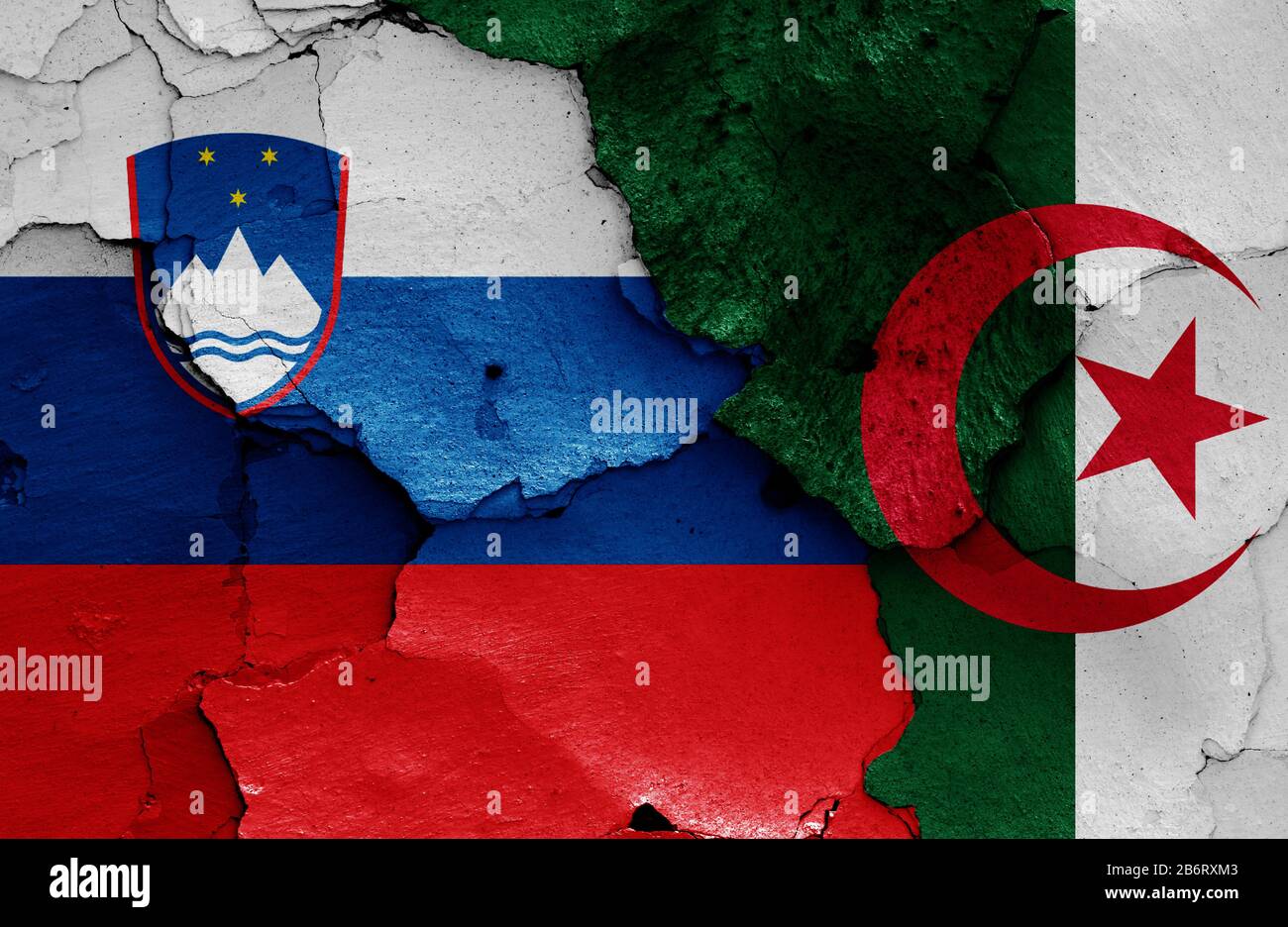 Drapeaux de la Slovénie et de l'Algérie peints sur un mur fissuré Banque D'Images