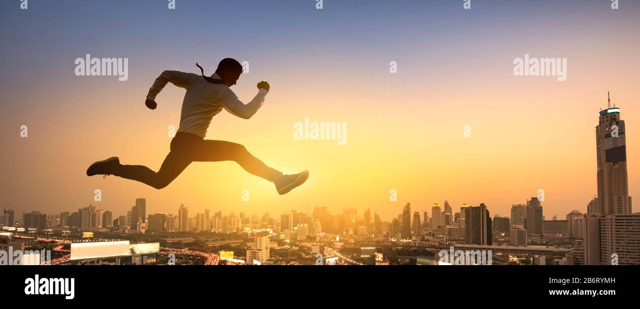 Jeune homme d'affaires sautant haut, travail, travail, ou concept d'affaires réussi. Paysage urbain arrière-plan. Banque D'Images