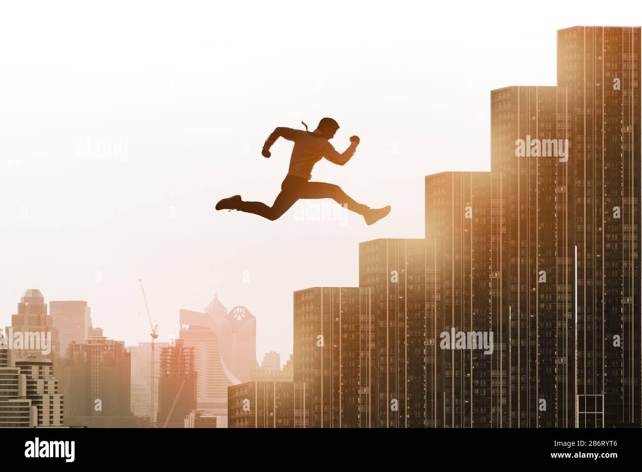 Les jeunes hommes d'affaires qui sautent sur l'escalier, célèbrent le succès gagnant pose sur le toit du bâtiment. Concept professionnel, professionnel ou commercial réussi. Paysage urbain Banque D'Images